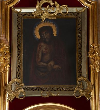 Zdjęcie nr 2: Nastawa ołtarzowa architektoniczna, jednoosiowa, jednokondygnacyjna ze zwieńczeniem. Mensa drewniana o profilowanej krawędzi. Ołtarz  sarkofagowy, na profilowanym cokole; na froncie intarsjowany wzór geometryczny. Kondygnacja ustawiona na profilowanym cokole, ujęta parą zdwojonych filarów o kanelowanych trzonach i kapitelach kompozytowych. Podpory dźwigają pełne belkowanie, wyłamane na ich osi, o wklęsło-wypukłym fryzie i silnie wysuniętym gzymsie oraz przerwany wolutowy przyczółek. W polu środkowym profilowana rama w formie stojącego prostokąta zamkniętego łukiem segmentowym nadwieszonym z uskokiem, z mniejszym obrazem wewnątrz w formie stojącego prostokąta, z przedstawieniem Ecce Homo. Przed filarami, na wklęsło-wypukłych postumentach dwie figury niezidentyfikowanych świętych. Zwieńczenie w formie leżącego prostokąta ujętego spływami wolutowymi, zamkniętego falistym gzymsem przechodzącym w zwrócone przeciwstawnie woluty. W polu rama o fantazyjnej formie zbliżonej do trójkąta z obrazem przedstawiającym Narodzenie Marii. Trzony filarów dekorowane kampanulami. W polu środkowym w przyłuczach rocaille. Rama obrazu na dłuższych bokach zdobiona ornamentem rocaille'owym. Nad polem środkowym w polu belkowania racaille'owy kartusz  z napisem: „ECCE HOMO”. W partii fryzu, na osiach podpór z trzech stron rozety. Struktura w całości laserunkowa, srebrzona, marmoryzowana; ornamentyka i profile złocone.