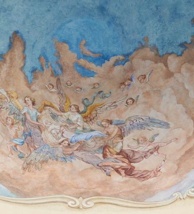 Zdjęcie nr 5: Polichromia umieszczona na półeliptycznej kopule nad kruchtą północną. Przedstawienie ujęte dekoracyjną ramą o fantazyjnym wykroju zdobioną klasycystycznymi wazonami, kartuszami i rogami obfitości. W dolnej części na jasnoczerwonej chmurze ukazane przedstawienie Zaśnięcia Najświętszej Marii Panny. Matka Boska wyobrażona w pozycji leżącej na prześcieradle unoszonym przez grupę aniołów. Maria leży z głową z lewej strony kompozycji z rękami złożonymi na piersi i z ugiętymi w kolanach nogami. Jest ubrana w jasnoróżową suknię, biały welon na głowie oraz niebieski płaszcz ułożony na jej nogach. Aniołowie są ubrani w różnokolorowe tuniki i płaszcze, mają też różne kolory skrzydeł. Przedstawienie okalają uskrzydlone główki aniołków oraz trójka półnagich putt sypiących kwiatki. W górnej części polichromii znajduje się odwrócony pejzaż z przedstawieniem kościoła w Brodach. W centrum jasnobłękitne niebo, a dookoła zielony pejzaż z drzewami. 