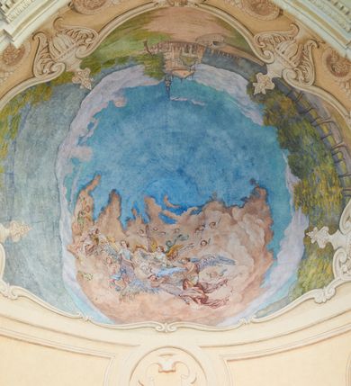 Zdjęcie nr 4: Polichromia umieszczona na półeliptycznej kopule nad kruchtą północną. Przedstawienie ujęte dekoracyjną ramą o fantazyjnym wykroju zdobioną klasycystycznymi wazonami, kartuszami i rogami obfitości. W dolnej części na jasnoczerwonej chmurze ukazane przedstawienie Zaśnięcia Najświętszej Marii Panny. Matka Boska wyobrażona w pozycji leżącej na prześcieradle unoszonym przez grupę aniołów. Maria leży z głową z lewej strony kompozycji z rękami złożonymi na piersi i z ugiętymi w kolanach nogami. Jest ubrana w jasnoróżową suknię, biały welon na głowie oraz niebieski płaszcz ułożony na jej nogach. Aniołowie są ubrani w różnokolorowe tuniki i płaszcze, mają też różne kolory skrzydeł. Przedstawienie okalają uskrzydlone główki aniołków oraz trójka półnagich putt sypiących kwiatki. W górnej części polichromii znajduje się odwrócony pejzaż z przedstawieniem kościoła w Brodach. W centrum jasnobłękitne niebo, a dookoła zielony pejzaż z drzewami. 