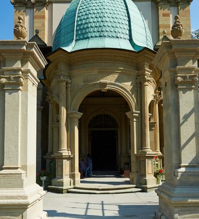 Zdjęcie nr 11: Kościół należy do zespołu dróżek Matki Boskiej, położnych w obrębie klasztoru w Kalwarii Zebrzydowskiej. Świątynia jest położna w centrum wsi, na wschód od głównej drogi, na placu otoczonym kamiennym murem z żeliwnym płotem, który od frontu ozdobiony jest figurami 12 apostołów, umieszczonymi na wysokich cokołach. Główne wejście na plac prowadzi przez bramę od zachodu, flankowaną dwoma filarami, na których ustawione są klasycystyczne wazony. Drugie wejście usytuowane jest od wschodu przez murowaną bramę, nakrytą daszkiem dwuspadowym, na którym ustawiona jest figura grającego na trąbie anioła. Trzecie wejście znajduje się od północy.

Kościół jest budowlą orientowaną, założoną na planie prostokąta, jednonawową, zamkniętą półkolistą absydą. Od zachodu przylega kruchta na planie prostokąta, zamkniętego z jednej strony półkoliście. Wewnątrz kościół dwupiętrowy. Na parterze część wschodnia świątyni podniesiona jest o siedem stopni, oddzielona od nawy trzema półkolistymi arkadami, wspartymi na czterech filarach i ustawionymi przed nimi półkolumnami, które wspierają pełne belkowanie, wyłamane na osiach. W przyłuczach płskorzeźbione główki aniołków. Na fryzie złocony napis: „EIA ADVOCATA NOSTRA OCVLOS MISERICORDES AD NOS CONVERTE ET IESVM BENEDICTV FRCTVM NOBIS OSTENDE”. Za środkową arkadą usytuowana jest niewielka, najstarsza część świątyni – Grób Matki Boskiej, na rzucie prostokąta, sklepiony krzyżowo. W ścianach bocznych nawy są półkoliście zamknięte wnęki na ołtarze. Od zachodu chór muzyczny wsparty jest na trzech arkadach filarowych. Wnętrze obiega drewniany ganek wsparty na metalowych wspornikach, a w części wschodniej i zachodniej na trzech murowanych arkadach. Podniebienie ganku zdobione jest geometrycznym stiukiem. W części nawowej świątyni znajduje się sklepienie kolebkowe z lunetami, w apsydzie hemisferyczne. Wnętrze doświetlone jest sześcioma małymi, okrągłymi oknami znajdującymi się na piętrze od strony północnej i południowej.

Fasada w dolnej części zaakcentowana jest przez monumentalną kruchtę w formie aediculi, założoną na rzucie prostokąta zamkniętego półkoliście. Ściany artykułowane są pięcioma półkolistymi arkadami, wspartymi na filarkach. Od zewnątrz osie ujęte są przez kanelowane kolumny, ustawione na wysokich cokołach, na tle pilastrów. Podpory wznoszą pełne belkowanie i wysunięty gzyms zdobiony kimationem i dekoracją kostkową. Nakrycie w formie kopuły półkolistej z latarnią. Belkowanie ozdobione jest dekoracją roślinną i główkami aniołków. Po bokach kruchty wysunięte są fragmenty muru oporowego do połowy wysokości fasady. Powyżej fasada flankowana przez dwie pary pilastrów z jońskimi kapitelami wspierającymi niepełne belkowanie. Pośrodku duże, półkoliste okno z metalową, dekoracyjną kratą. Szczyt trójkątny z oculusem pośrodku. Na szczycie ustawiona jest figura Najświętszej Marii Panny. Świątynia dookoła obwiedziona szerokim murem oporowym, nakrytym daszkiem, o ukośnych ścianach, flankowanych szkarpami, po sześć na każdej ścianie bocznej i dwoma na ścianie zachodniej oraz wschodniej. Powyżej elewacje ujęte pilastrami z kapitelami jońskimi wznoszącymi niepełne belkowanie. Na wschodniej ścianie półkolista apsyda, nakryta półkopułą. Kościół nakryty dachem siodłowym ze zdwojoną, wysoką latarnią pośrodku. Na narożach dachu ustawione wysokie obeliski na cokołach. 

 