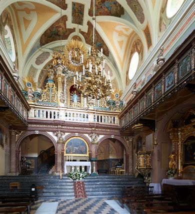 Zdjęcie nr 41: Kościół należy do zespołu dróżek Matki Boskiej, położnych w obrębie klasztoru w Kalwarii Zebrzydowskiej. Świątynia jest położna w centrum wsi, na wschód od głównej drogi, na placu otoczonym kamiennym murem z żeliwnym płotem, który od frontu ozdobiony jest figurami 12 apostołów, umieszczonymi na wysokich cokołach. Główne wejście na plac prowadzi przez bramę od zachodu, flankowaną dwoma filarami, na których ustawione są klasycystyczne wazony. Drugie wejście usytuowane jest od wschodu przez murowaną bramę, nakrytą daszkiem dwuspadowym, na którym ustawiona jest figura grającego na trąbie anioła. Trzecie wejście znajduje się od północy.

Kościół jest budowlą orientowaną, założoną na planie prostokąta, jednonawową, zamkniętą półkolistą absydą. Od zachodu przylega kruchta na planie prostokąta, zamkniętego z jednej strony półkoliście. Wewnątrz kościół dwupiętrowy. Na parterze część wschodnia świątyni podniesiona jest o siedem stopni, oddzielona od nawy trzema półkolistymi arkadami, wspartymi na czterech filarach i ustawionymi przed nimi półkolumnami, które wspierają pełne belkowanie, wyłamane na osiach. W przyłuczach płskorzeźbione główki aniołków. Na fryzie złocony napis: „EIA ADVOCATA NOSTRA OCVLOS MISERICORDES AD NOS CONVERTE ET IESVM BENEDICTV FRCTVM NOBIS OSTENDE”. Za środkową arkadą usytuowana jest niewielka, najstarsza część świątyni – Grób Matki Boskiej, na rzucie prostokąta, sklepiony krzyżowo. W ścianach bocznych nawy są półkoliście zamknięte wnęki na ołtarze. Od zachodu chór muzyczny wsparty jest na trzech arkadach filarowych. Wnętrze obiega drewniany ganek wsparty na metalowych wspornikach, a w części wschodniej i zachodniej na trzech murowanych arkadach. Podniebienie ganku zdobione jest geometrycznym stiukiem. W części nawowej świątyni znajduje się sklepienie kolebkowe z lunetami, w apsydzie hemisferyczne. Wnętrze doświetlone jest sześcioma małymi, okrągłymi oknami znajdującymi się na piętrze od strony północnej i południowej.

Fasada w dolnej części zaakcentowana jest przez monumentalną kruchtę w formie aediculi, założoną na rzucie prostokąta zamkniętego półkoliście. Ściany artykułowane są pięcioma półkolistymi arkadami, wspartymi na filarkach. Od zewnątrz osie ujęte są przez kanelowane kolumny, ustawione na wysokich cokołach, na tle pilastrów. Podpory wznoszą pełne belkowanie i wysunięty gzyms zdobiony kimationem i dekoracją kostkową. Nakrycie w formie kopuły półkolistej z latarnią. Belkowanie ozdobione jest dekoracją roślinną i główkami aniołków. Po bokach kruchty wysunięte są fragmenty muru oporowego do połowy wysokości fasady. Powyżej fasada flankowana przez dwie pary pilastrów z jońskimi kapitelami wspierającymi niepełne belkowanie. Pośrodku duże, półkoliste okno z metalową, dekoracyjną kratą. Szczyt trójkątny z oculusem pośrodku. Na szczycie ustawiona jest figura Najświętszej Marii Panny. Świątynia dookoła obwiedziona szerokim murem oporowym, nakrytym daszkiem, o ukośnych ścianach, flankowanych szkarpami, po sześć na każdej ścianie bocznej i dwoma na ścianie zachodniej oraz wschodniej. Powyżej elewacje ujęte pilastrami z kapitelami jońskimi wznoszącymi niepełne belkowanie. Na wschodniej ścianie półkolista apsyda, nakryta półkopułą. Kościół nakryty dachem siodłowym ze zdwojoną, wysoką latarnią pośrodku. Na narożach dachu ustawione wysokie obeliski na cokołach. 

 