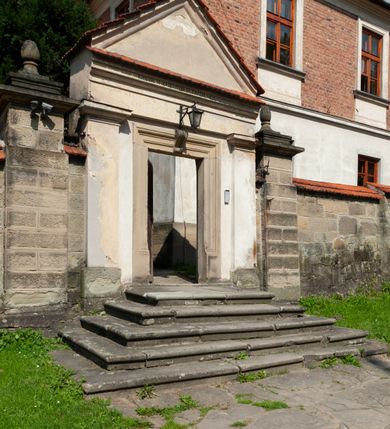 Zdjęcie nr 6: Kościół należy do zespołu dróżek Matki Boskiej, położnych w obrębie klasztoru w Kalwarii Zebrzydowskiej. Świątynia jest położna w centrum wsi, na wschód od głównej drogi, na placu otoczonym kamiennym murem z żeliwnym płotem, który od frontu ozdobiony jest figurami 12 apostołów, umieszczonymi na wysokich cokołach. Główne wejście na plac prowadzi przez bramę od zachodu, flankowaną dwoma filarami, na których ustawione są klasycystyczne wazony. Drugie wejście usytuowane jest od wschodu przez murowaną bramę, nakrytą daszkiem dwuspadowym, na którym ustawiona jest figura grającego na trąbie anioła. Trzecie wejście znajduje się od północy.

Kościół jest budowlą orientowaną, założoną na planie prostokąta, jednonawową, zamkniętą półkolistą absydą. Od zachodu przylega kruchta na planie prostokąta, zamkniętego z jednej strony półkoliście. Wewnątrz kościół dwupiętrowy. Na parterze część wschodnia świątyni podniesiona jest o siedem stopni, oddzielona od nawy trzema półkolistymi arkadami, wspartymi na czterech filarach i ustawionymi przed nimi półkolumnami, które wspierają pełne belkowanie, wyłamane na osiach. W przyłuczach płskorzeźbione główki aniołków. Na fryzie złocony napis: „EIA ADVOCATA NOSTRA OCVLOS MISERICORDES AD NOS CONVERTE ET IESVM BENEDICTV FRCTVM NOBIS OSTENDE”. Za środkową arkadą usytuowana jest niewielka, najstarsza część świątyni – Grób Matki Boskiej, na rzucie prostokąta, sklepiony krzyżowo. W ścianach bocznych nawy są półkoliście zamknięte wnęki na ołtarze. Od zachodu chór muzyczny wsparty jest na trzech arkadach filarowych. Wnętrze obiega drewniany ganek wsparty na metalowych wspornikach, a w części wschodniej i zachodniej na trzech murowanych arkadach. Podniebienie ganku zdobione jest geometrycznym stiukiem. W części nawowej świątyni znajduje się sklepienie kolebkowe z lunetami, w apsydzie hemisferyczne. Wnętrze doświetlone jest sześcioma małymi, okrągłymi oknami znajdującymi się na piętrze od strony północnej i południowej.

Fasada w dolnej części zaakcentowana jest przez monumentalną kruchtę w formie aediculi, założoną na rzucie prostokąta zamkniętego półkoliście. Ściany artykułowane są pięcioma półkolistymi arkadami, wspartymi na filarkach. Od zewnątrz osie ujęte są przez kanelowane kolumny, ustawione na wysokich cokołach, na tle pilastrów. Podpory wznoszą pełne belkowanie i wysunięty gzyms zdobiony kimationem i dekoracją kostkową. Nakrycie w formie kopuły półkolistej z latarnią. Belkowanie ozdobione jest dekoracją roślinną i główkami aniołków. Po bokach kruchty wysunięte są fragmenty muru oporowego do połowy wysokości fasady. Powyżej fasada flankowana przez dwie pary pilastrów z jońskimi kapitelami wspierającymi niepełne belkowanie. Pośrodku duże, półkoliste okno z metalową, dekoracyjną kratą. Szczyt trójkątny z oculusem pośrodku. Na szczycie ustawiona jest figura Najświętszej Marii Panny. Świątynia dookoła obwiedziona szerokim murem oporowym, nakrytym daszkiem, o ukośnych ścianach, flankowanych szkarpami, po sześć na każdej ścianie bocznej i dwoma na ścianie zachodniej oraz wschodniej. Powyżej elewacje ujęte pilastrami z kapitelami jońskimi wznoszącymi niepełne belkowanie. Na wschodniej ścianie półkolista apsyda, nakryta półkopułą. Kościół nakryty dachem siodłowym ze zdwojoną, wysoką latarnią pośrodku. Na narożach dachu ustawione wysokie obeliski na cokołach. 

 