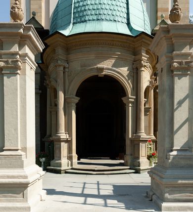 Zdjęcie nr 14: Kościół należy do zespołu dróżek Matki Boskiej, położnych w obrębie klasztoru w Kalwarii Zebrzydowskiej. Świątynia jest położna w centrum wsi, na wschód od głównej drogi, na placu otoczonym kamiennym murem z żeliwnym płotem, który od frontu ozdobiony jest figurami 12 apostołów, umieszczonymi na wysokich cokołach. Główne wejście na plac prowadzi przez bramę od zachodu, flankowaną dwoma filarami, na których ustawione są klasycystyczne wazony. Drugie wejście usytuowane jest od wschodu przez murowaną bramę, nakrytą daszkiem dwuspadowym, na którym ustawiona jest figura grającego na trąbie anioła. Trzecie wejście znajduje się od północy.

Kościół jest budowlą orientowaną, założoną na planie prostokąta, jednonawową, zamkniętą półkolistą absydą. Od zachodu przylega kruchta na planie prostokąta, zamkniętego z jednej strony półkoliście. Wewnątrz kościół dwupiętrowy. Na parterze część wschodnia świątyni podniesiona jest o siedem stopni, oddzielona od nawy trzema półkolistymi arkadami, wspartymi na czterech filarach i ustawionymi przed nimi półkolumnami, które wspierają pełne belkowanie, wyłamane na osiach. W przyłuczach płskorzeźbione główki aniołków. Na fryzie złocony napis: „EIA ADVOCATA NOSTRA OCVLOS MISERICORDES AD NOS CONVERTE ET IESVM BENEDICTV FRCTVM NOBIS OSTENDE”. Za środkową arkadą usytuowana jest niewielka, najstarsza część świątyni – Grób Matki Boskiej, na rzucie prostokąta, sklepiony krzyżowo. W ścianach bocznych nawy są półkoliście zamknięte wnęki na ołtarze. Od zachodu chór muzyczny wsparty jest na trzech arkadach filarowych. Wnętrze obiega drewniany ganek wsparty na metalowych wspornikach, a w części wschodniej i zachodniej na trzech murowanych arkadach. Podniebienie ganku zdobione jest geometrycznym stiukiem. W części nawowej świątyni znajduje się sklepienie kolebkowe z lunetami, w apsydzie hemisferyczne. Wnętrze doświetlone jest sześcioma małymi, okrągłymi oknami znajdującymi się na piętrze od strony północnej i południowej.

Fasada w dolnej części zaakcentowana jest przez monumentalną kruchtę w formie aediculi, założoną na rzucie prostokąta zamkniętego półkoliście. Ściany artykułowane są pięcioma półkolistymi arkadami, wspartymi na filarkach. Od zewnątrz osie ujęte są przez kanelowane kolumny, ustawione na wysokich cokołach, na tle pilastrów. Podpory wznoszą pełne belkowanie i wysunięty gzyms zdobiony kimationem i dekoracją kostkową. Nakrycie w formie kopuły półkolistej z latarnią. Belkowanie ozdobione jest dekoracją roślinną i główkami aniołków. Po bokach kruchty wysunięte są fragmenty muru oporowego do połowy wysokości fasady. Powyżej fasada flankowana przez dwie pary pilastrów z jońskimi kapitelami wspierającymi niepełne belkowanie. Pośrodku duże, półkoliste okno z metalową, dekoracyjną kratą. Szczyt trójkątny z oculusem pośrodku. Na szczycie ustawiona jest figura Najświętszej Marii Panny. Świątynia dookoła obwiedziona szerokim murem oporowym, nakrytym daszkiem, o ukośnych ścianach, flankowanych szkarpami, po sześć na każdej ścianie bocznej i dwoma na ścianie zachodniej oraz wschodniej. Powyżej elewacje ujęte pilastrami z kapitelami jońskimi wznoszącymi niepełne belkowanie. Na wschodniej ścianie półkolista apsyda, nakryta półkopułą. Kościół nakryty dachem siodłowym ze zdwojoną, wysoką latarnią pośrodku. Na narożach dachu ustawione wysokie obeliski na cokołach. 

 