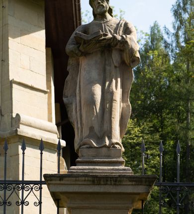 Zdjęcie nr 80: Kościół należy do zespołu dróżek Matki Boskiej, położnych w obrębie klasztoru w Kalwarii Zebrzydowskiej. Świątynia jest położna w centrum wsi, na wschód od głównej drogi, na placu otoczonym kamiennym murem z żeliwnym płotem, który od frontu ozdobiony jest figurami 12 apostołów, umieszczonymi na wysokich cokołach. Główne wejście na plac prowadzi przez bramę od zachodu, flankowaną dwoma filarami, na których ustawione są klasycystyczne wazony. Drugie wejście usytuowane jest od wschodu przez murowaną bramę, nakrytą daszkiem dwuspadowym, na którym ustawiona jest figura grającego na trąbie anioła. Trzecie wejście znajduje się od północy.

Kościół jest budowlą orientowaną, założoną na planie prostokąta, jednonawową, zamkniętą półkolistą absydą. Od zachodu przylega kruchta na planie prostokąta, zamkniętego z jednej strony półkoliście. Wewnątrz kościół dwupiętrowy. Na parterze część wschodnia świątyni podniesiona jest o siedem stopni, oddzielona od nawy trzema półkolistymi arkadami, wspartymi na czterech filarach i ustawionymi przed nimi półkolumnami, które wspierają pełne belkowanie, wyłamane na osiach. W przyłuczach płskorzeźbione główki aniołków. Na fryzie złocony napis: „EIA ADVOCATA NOSTRA OCVLOS MISERICORDES AD NOS CONVERTE ET IESVM BENEDICTV FRCTVM NOBIS OSTENDE”. Za środkową arkadą usytuowana jest niewielka, najstarsza część świątyni – Grób Matki Boskiej, na rzucie prostokąta, sklepiony krzyżowo. W ścianach bocznych nawy są półkoliście zamknięte wnęki na ołtarze. Od zachodu chór muzyczny wsparty jest na trzech arkadach filarowych. Wnętrze obiega drewniany ganek wsparty na metalowych wspornikach, a w części wschodniej i zachodniej na trzech murowanych arkadach. Podniebienie ganku zdobione jest geometrycznym stiukiem. W części nawowej świątyni znajduje się sklepienie kolebkowe z lunetami, w apsydzie hemisferyczne. Wnętrze doświetlone jest sześcioma małymi, okrągłymi oknami znajdującymi się na piętrze od strony północnej i południowej.

Fasada w dolnej części zaakcentowana jest przez monumentalną kruchtę w formie aediculi, założoną na rzucie prostokąta zamkniętego półkoliście. Ściany artykułowane są pięcioma półkolistymi arkadami, wspartymi na filarkach. Od zewnątrz osie ujęte są przez kanelowane kolumny, ustawione na wysokich cokołach, na tle pilastrów. Podpory wznoszą pełne belkowanie i wysunięty gzyms zdobiony kimationem i dekoracją kostkową. Nakrycie w formie kopuły półkolistej z latarnią. Belkowanie ozdobione jest dekoracją roślinną i główkami aniołków. Po bokach kruchty wysunięte są fragmenty muru oporowego do połowy wysokości fasady. Powyżej fasada flankowana przez dwie pary pilastrów z jońskimi kapitelami wspierającymi niepełne belkowanie. Pośrodku duże, półkoliste okno z metalową, dekoracyjną kratą. Szczyt trójkątny z oculusem pośrodku. Na szczycie ustawiona jest figura Najświętszej Marii Panny. Świątynia dookoła obwiedziona szerokim murem oporowym, nakrytym daszkiem, o ukośnych ścianach, flankowanych szkarpami, po sześć na każdej ścianie bocznej i dwoma na ścianie zachodniej oraz wschodniej. Powyżej elewacje ujęte pilastrami z kapitelami jońskimi wznoszącymi niepełne belkowanie. Na wschodniej ścianie półkolista apsyda, nakryta półkopułą. Kościół nakryty dachem siodłowym ze zdwojoną, wysoką latarnią pośrodku. Na narożach dachu ustawione wysokie obeliski na cokołach. 

 