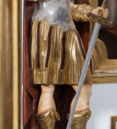 Zdjęcie nr 8: Ołtarz drewniany, prostopadłościenny. Mensa drewniana, sarkofagowa, antepedium zdobione płaskorzeźbionym kartuszem z umieszczonym w polu godłem herbu Uniwersytetu Krakowskiego na czerwonym tle.

 Nastawa architektoniczna, trójosiowa, jednokondygnacyjna ze zwieńczeniem, osadzona na dwustrefowym cokole, o osiach bocznych ustawionych ukośnie. Kondygnacja ujęta parą pilastrów oraz dwiema parami kolumn podtrzymujących przerwane belkowanie,  na którym znajduje się para puttów. W polu środkowym obraz z przedstawieniem Matki Boskiej od Odkupienia Niewolników ujęty prostokątną, profilowaną ramą zamkniętą łukiem nadwieszonym. Na cokole, po bokach obrazu ustawione dwie rzeźby: po lewej św. Kryspina, po prawej św. Kryspiniana; w osiach bocznych, w płytkich wnękach: po lewej rzeźba św. Szczepana, po prawej św. Wawrzyńca. Nad obrazem Matki Boskiej płaskorzeźbiony kartusz rocaille’owy z wpisanym w polu napisem „O / MARYO / odkupicielko / więźniów / módl się / za nami!”.

 Zwieńczenie w formie rozbudowanej aediculi, o osiach bocznych ustawionych ukośnie, z przodu flankowane dwiema wolutami z siedzącą na nich parą aniołków, zamknięte przerywanym, profilowanym gzymsem z ulokowaną na nim parą wazonów płomienistych. W polu zwieńczenia płycina wypełniona obłokami, o fantazyjnym kartuszowym wykroju z przedstawieniem Oka Opatrzności wpisanym w trójkąt na tle trzech wiązek promieni. Szczyt jest w formie promienistej glorii z parą uskrzydlonych główek anielskich.

 Kolumny złocone, ustawione na profilowanych bazach, o gładkim trzonie, kapitele w porządku kompozytowym.

 Partie cokołu zdobione prostokątnymi płycinami o wyciętych narożach.

 Struktura malowana w kolorze jasnobeżowym, ornamentyka i detale złocone i srebrzone, profilowania w kolorze czerwonym i złoconym.