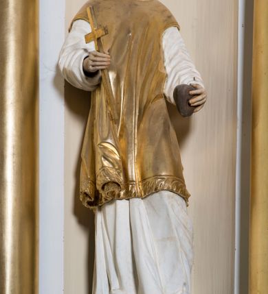 Zdjęcie nr 17: Ołtarz drewniany, prostopadłościenny. Mensa drewniana, sarkofagowa, antepedium zdobione płaskorzeźbionym kartuszem z umieszczonym w polu godłem herbu Uniwersytetu Krakowskiego na czerwonym tle.

 Nastawa architektoniczna, trójosiowa, jednokondygnacyjna ze zwieńczeniem, osadzona na dwustrefowym cokole, o osiach bocznych ustawionych ukośnie. Kondygnacja ujęta parą pilastrów oraz dwiema parami kolumn podtrzymujących przerwane belkowanie,  na którym znajduje się para puttów. W polu środkowym obraz z przedstawieniem Matki Boskiej od Odkupienia Niewolników ujęty prostokątną, profilowaną ramą zamkniętą łukiem nadwieszonym. Na cokole, po bokach obrazu ustawione dwie rzeźby: po lewej św. Kryspina, po prawej św. Kryspiniana; w osiach bocznych, w płytkich wnękach: po lewej rzeźba św. Szczepana, po prawej św. Wawrzyńca. Nad obrazem Matki Boskiej płaskorzeźbiony kartusz rocaille’owy z wpisanym w polu napisem „O / MARYO / odkupicielko / więźniów / módl się / za nami!”.

 Zwieńczenie w formie rozbudowanej aediculi, o osiach bocznych ustawionych ukośnie, z przodu flankowane dwiema wolutami z siedzącą na nich parą aniołków, zamknięte przerywanym, profilowanym gzymsem z ulokowaną na nim parą wazonów płomienistych. W polu zwieńczenia płycina wypełniona obłokami, o fantazyjnym kartuszowym wykroju z przedstawieniem Oka Opatrzności wpisanym w trójkąt na tle trzech wiązek promieni. Szczyt jest w formie promienistej glorii z parą uskrzydlonych główek anielskich.

 Kolumny złocone, ustawione na profilowanych bazach, o gładkim trzonie, kapitele w porządku kompozytowym.

 Partie cokołu zdobione prostokątnymi płycinami o wyciętych narożach.

 Struktura malowana w kolorze jasnobeżowym, ornamentyka i detale złocone i srebrzone, profilowania w kolorze czerwonym i złoconym.