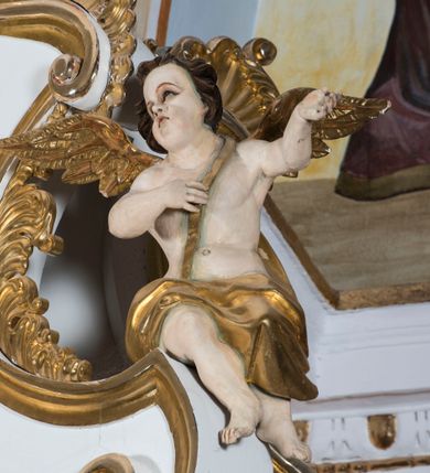 Zdjęcie nr 25: Ołtarz drewniany, prostopadłościenny. Mensa drewniana, sarkofagowa, antepedium zdobione płaskorzeźbionym kartuszem z umieszczonym w polu godłem herbu Uniwersytetu Krakowskiego na czerwonym tle.

 Nastawa architektoniczna, trójosiowa, jednokondygnacyjna ze zwieńczeniem, osadzona na dwustrefowym cokole, o osiach bocznych ustawionych ukośnie. Kondygnacja ujęta parą pilastrów oraz dwiema parami kolumn podtrzymujących przerwane belkowanie,  na którym znajduje się para puttów. W polu środkowym obraz z przedstawieniem Matki Boskiej od Odkupienia Niewolników ujęty prostokątną, profilowaną ramą zamkniętą łukiem nadwieszonym. Na cokole, po bokach obrazu ustawione dwie rzeźby: po lewej św. Kryspina, po prawej św. Kryspiniana; w osiach bocznych, w płytkich wnękach: po lewej rzeźba św. Szczepana, po prawej św. Wawrzyńca. Nad obrazem Matki Boskiej płaskorzeźbiony kartusz rocaille’owy z wpisanym w polu napisem „O / MARYO / odkupicielko / więźniów / módl się / za nami!”.

 Zwieńczenie w formie rozbudowanej aediculi, o osiach bocznych ustawionych ukośnie, z przodu flankowane dwiema wolutami z siedzącą na nich parą aniołków, zamknięte przerywanym, profilowanym gzymsem z ulokowaną na nim parą wazonów płomienistych. W polu zwieńczenia płycina wypełniona obłokami, o fantazyjnym kartuszowym wykroju z przedstawieniem Oka Opatrzności wpisanym w trójkąt na tle trzech wiązek promieni. Szczyt jest w formie promienistej glorii z parą uskrzydlonych główek anielskich.

 Kolumny złocone, ustawione na profilowanych bazach, o gładkim trzonie, kapitele w porządku kompozytowym.

 Partie cokołu zdobione prostokątnymi płycinami o wyciętych narożach.

 Struktura malowana w kolorze jasnobeżowym, ornamentyka i detale złocone i srebrzone, profilowania w kolorze czerwonym i złoconym.