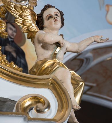 Zdjęcie nr 28: Ołtarz drewniany, prostopadłościenny. Mensa drewniana, sarkofagowa, antepedium zdobione płaskorzeźbionym kartuszem z umieszczonym w polu godłem herbu Uniwersytetu Krakowskiego na czerwonym tle.

 Nastawa architektoniczna, trójosiowa, jednokondygnacyjna ze zwieńczeniem, osadzona na dwustrefowym cokole, o osiach bocznych ustawionych ukośnie. Kondygnacja ujęta parą pilastrów oraz dwiema parami kolumn podtrzymujących przerwane belkowanie,  na którym znajduje się para puttów. W polu środkowym obraz z przedstawieniem Matki Boskiej od Odkupienia Niewolników ujęty prostokątną, profilowaną ramą zamkniętą łukiem nadwieszonym. Na cokole, po bokach obrazu ustawione dwie rzeźby: po lewej św. Kryspina, po prawej św. Kryspiniana; w osiach bocznych, w płytkich wnękach: po lewej rzeźba św. Szczepana, po prawej św. Wawrzyńca. Nad obrazem Matki Boskiej płaskorzeźbiony kartusz rocaille’owy z wpisanym w polu napisem „O / MARYO / odkupicielko / więźniów / módl się / za nami!”.

 Zwieńczenie w formie rozbudowanej aediculi, o osiach bocznych ustawionych ukośnie, z przodu flankowane dwiema wolutami z siedzącą na nich parą aniołków, zamknięte przerywanym, profilowanym gzymsem z ulokowaną na nim parą wazonów płomienistych. W polu zwieńczenia płycina wypełniona obłokami, o fantazyjnym kartuszowym wykroju z przedstawieniem Oka Opatrzności wpisanym w trójkąt na tle trzech wiązek promieni. Szczyt jest w formie promienistej glorii z parą uskrzydlonych główek anielskich.

 Kolumny złocone, ustawione na profilowanych bazach, o gładkim trzonie, kapitele w porządku kompozytowym.

 Partie cokołu zdobione prostokątnymi płycinami o wyciętych narożach.

 Struktura malowana w kolorze jasnobeżowym, ornamentyka i detale złocone i srebrzone, profilowania w kolorze czerwonym i złoconym.