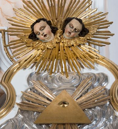 Zdjęcie nr 5: Ołtarz drewniany, prostopadłościenny. Mensa drewniana, sarkofagowa, antepedium zdobione płaskorzeźbionym kartuszem z umieszczonym w polu godłem herbu Uniwersytetu Krakowskiego na czerwonym tle.

 Nastawa architektoniczna, trójosiowa, jednokondygnacyjna ze zwieńczeniem, osadzona na dwustrefowym cokole, o osiach bocznych ustawionych ukośnie. Kondygnacja ujęta parą pilastrów oraz dwiema parami kolumn podtrzymujących przerwane belkowanie,  na którym znajduje się para puttów. W polu środkowym obraz z przedstawieniem Matki Boskiej od Odkupienia Niewolników ujęty prostokątną, profilowaną ramą zamkniętą łukiem nadwieszonym. Na cokole, po bokach obrazu ustawione dwie rzeźby: po lewej św. Kryspina, po prawej św. Kryspiniana; w osiach bocznych, w płytkich wnękach: po lewej rzeźba św. Szczepana, po prawej św. Wawrzyńca. Nad obrazem Matki Boskiej płaskorzeźbiony kartusz rocaille’owy z wpisanym w polu napisem „O / MARYO / odkupicielko / więźniów / módl się / za nami!”.

 Zwieńczenie w formie rozbudowanej aediculi, o osiach bocznych ustawionych ukośnie, z przodu flankowane dwiema wolutami z siedzącą na nich parą aniołków, zamknięte przerywanym, profilowanym gzymsem z ulokowaną na nim parą wazonów płomienistych. W polu zwieńczenia płycina wypełniona obłokami, o fantazyjnym kartuszowym wykroju z przedstawieniem Oka Opatrzności wpisanym w trójkąt na tle trzech wiązek promieni. Szczyt jest w formie promienistej glorii z parą uskrzydlonych główek anielskich.

 Kolumny złocone, ustawione na profilowanych bazach, o gładkim trzonie, kapitele w porządku kompozytowym.

 Partie cokołu zdobione prostokątnymi płycinami o wyciętych narożach.

 Struktura malowana w kolorze jasnobeżowym, ornamentyka i detale złocone i srebrzone, profilowania w kolorze czerwonym i złoconym.