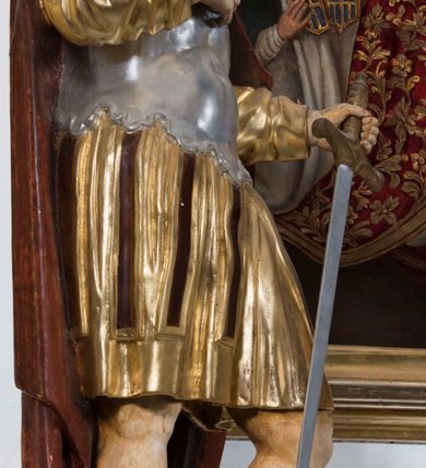 Zdjęcie nr 10: Ołtarz drewniany, prostopadłościenny. Mensa drewniana, sarkofagowa, antepedium zdobione płaskorzeźbionym kartuszem z umieszczonym w polu godłem herbu Uniwersytetu Krakowskiego na czerwonym tle.

 Nastawa architektoniczna, trójosiowa, jednokondygnacyjna ze zwieńczeniem, osadzona na dwustrefowym cokole, o osiach bocznych ustawionych ukośnie. Kondygnacja ujęta parą pilastrów oraz dwiema parami kolumn podtrzymujących przerwane belkowanie,  na którym znajduje się para puttów. W polu środkowym obraz z przedstawieniem Matki Boskiej od Odkupienia Niewolników ujęty prostokątną, profilowaną ramą zamkniętą łukiem nadwieszonym. Na cokole, po bokach obrazu ustawione dwie rzeźby: po lewej św. Kryspina, po prawej św. Kryspiniana; w osiach bocznych, w płytkich wnękach: po lewej rzeźba św. Szczepana, po prawej św. Wawrzyńca. Nad obrazem Matki Boskiej płaskorzeźbiony kartusz rocaille’owy z wpisanym w polu napisem „O / MARYO / odkupicielko / więźniów / módl się / za nami!”.

 Zwieńczenie w formie rozbudowanej aediculi, o osiach bocznych ustawionych ukośnie, z przodu flankowane dwiema wolutami z siedzącą na nich parą aniołków, zamknięte przerywanym, profilowanym gzymsem z ulokowaną na nim parą wazonów płomienistych. W polu zwieńczenia płycina wypełniona obłokami, o fantazyjnym kartuszowym wykroju z przedstawieniem Oka Opatrzności wpisanym w trójkąt na tle trzech wiązek promieni. Szczyt jest w formie promienistej glorii z parą uskrzydlonych główek anielskich.

 Kolumny złocone, ustawione na profilowanych bazach, o gładkim trzonie, kapitele w porządku kompozytowym.

 Partie cokołu zdobione prostokątnymi płycinami o wyciętych narożach.

 Struktura malowana w kolorze jasnobeżowym, ornamentyka i detale złocone i srebrzone, profilowania w kolorze czerwonym i złoconym.