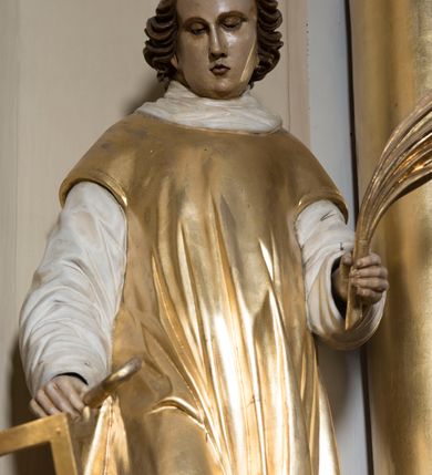 Zdjęcie nr 19: Ołtarz drewniany, prostopadłościenny. Mensa drewniana, sarkofagowa, antepedium zdobione płaskorzeźbionym kartuszem z umieszczonym w polu godłem herbu Uniwersytetu Krakowskiego na czerwonym tle.

 Nastawa architektoniczna, trójosiowa, jednokondygnacyjna ze zwieńczeniem, osadzona na dwustrefowym cokole, o osiach bocznych ustawionych ukośnie. Kondygnacja ujęta parą pilastrów oraz dwiema parami kolumn podtrzymujących przerwane belkowanie,  na którym znajduje się para puttów. W polu środkowym obraz z przedstawieniem Matki Boskiej od Odkupienia Niewolników ujęty prostokątną, profilowaną ramą zamkniętą łukiem nadwieszonym. Na cokole, po bokach obrazu ustawione dwie rzeźby: po lewej św. Kryspina, po prawej św. Kryspiniana; w osiach bocznych, w płytkich wnękach: po lewej rzeźba św. Szczepana, po prawej św. Wawrzyńca. Nad obrazem Matki Boskiej płaskorzeźbiony kartusz rocaille’owy z wpisanym w polu napisem „O / MARYO / odkupicielko / więźniów / módl się / za nami!”.

 Zwieńczenie w formie rozbudowanej aediculi, o osiach bocznych ustawionych ukośnie, z przodu flankowane dwiema wolutami z siedzącą na nich parą aniołków, zamknięte przerywanym, profilowanym gzymsem z ulokowaną na nim parą wazonów płomienistych. W polu zwieńczenia płycina wypełniona obłokami, o fantazyjnym kartuszowym wykroju z przedstawieniem Oka Opatrzności wpisanym w trójkąt na tle trzech wiązek promieni. Szczyt jest w formie promienistej glorii z parą uskrzydlonych główek anielskich.

 Kolumny złocone, ustawione na profilowanych bazach, o gładkim trzonie, kapitele w porządku kompozytowym.

 Partie cokołu zdobione prostokątnymi płycinami o wyciętych narożach.

 Struktura malowana w kolorze jasnobeżowym, ornamentyka i detale złocone i srebrzone, profilowania w kolorze czerwonym i złoconym.