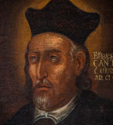 Zdjęcie nr 3: Obraz w kształcie stojącego prostokąta zawiera wizerunek św. Jana Kantego ukazanego w półpostaci, w trzech czwartych zwróconego w prawo. Szczupłą, pociągłą twarz świętego charakteryzują naturalistycznie opracowane rysy z pokrytym drobnymi bruzdami czołem, zwróconymi ku górze, niewielkimi, szeroko osadzonymi oczami, długim, lekko zakrzywionym nosem, wydatnymi kośćmi policzkowymi oraz nieznacznie rozchylonymi ustami widocznymi pomiędzy krótkim, siwym zarostem. Widoczne spod nakrywającego głowę biretu siwe włosy są lekko skręcone i sięgają ramion mężczyzny. Święty Jan Kanty ubrany jest w togę profesorską, ręce ma złożone w geście modlitwy. Głowę świętego okala świetlisty nimb. Postać ukazana jest na ciemnobrązowym, jednolitym tle. Po lewej stronie widoczny jest niewielki krucyfiks, po prawej w głębi grzbiety ksiąg, powyżej, na wysokości głowy świętego znajduje się napis „Effigies S(ancti) IOANṄIS / CANTY post sacrum / è vivis exspiriu(m) deline/ata et depicta, A(nno) D(omini) 1473.”.