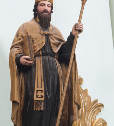 Zdjęcie nr 21: Retabulum ołtarza bocznego charakteryzuje architektoniczna, jednokondygnacyjna, jednoosiowa struktura ze zwieńczeniem. Ołtarz jest drewniany, sarkofagowy z drewnianą mensą. Retabulum osadzone jest na zdwojonym cokole. Część środkowa nastawy ujęta jest parą kolumn i dwoma parami pilastrów, z których jedna ma wklęsłe trzony. Wspomniane elementy wspierają wyłamujące się ponad nimi wklęsło-wypukłe belkowanie. Pole środkowe retabulum jest w kształcie stojącego prostokąta zamkniętego półkolistym łukiem nadwieszonym z uskokami, ujęte jest profilowaną, złoconą ramą. Zwieńczenie, w kształcie stojącego prostokąta zamknięte jest gzymsem w formie nadwieszonego łuku z uskokami. Pole środkowe stanowi owalny prześwit ujęty profilowaną, złoconą ramą. Po bokach zwieńczenia usytuowany jest przerwany, skośnie ustawiony wolutowy przyczółek. Po środku antepedium znajduje się polichromowane gorejące serce Jezusa ujęte gałązkami czerwonej róży. Pola cokołów zdobi ornamentyka rocaille’owo-akantowa. Część środkową retabulum ujmuje para ażurowych uszaków z liści akantu z motywami kogucich grzebieni. Trzony wklęsłych pilastrów w dolnej partii zdobią motywy wolut zwieńczonych liśćmi akantu. W górnej partii trzonów wszystkich pilastrów znajdują się podwieszenia w formie związanych wstążkami kompozycji kwiatowo-owocowych. Kapitele zdobione są detalami ze stylizowanych liści akantu oraz niewielkimi konsolkami z motywem palmety. Fryz dekorują motywy ornamentyki rocaille’owej. Krawędź gzymsu zwieńczenia ujęta jest rodzajem lambrekinu z pojedynczych liści o lancetowatym kształcie. W prześwit wkomponowana została promienista gloria z monogramem Jezusa pośrodku, na ciemnoczerwonym tle, ujęta wieńcem srebrzonych obłoków. W polu części środkowej retabulum znajduje się obraz Najświętsze Serce Jezusa, dodatkowo po bokach, na półkoliście wysuniętych partiach cokołu retabulum usytuowana jest para niewielkich rzeźb św. Rocha i św. Grzegorza Wielkiego. Na przerwanym przyczółku znajduje się para figur aniołów. 
Struktura retabulum utrzymana jest w pastelowym odcieniu turkusu z akcentem ciemnej czerwieni, partie detalu architektonicznego i ornamentyka są złocone i srebrzone.    
