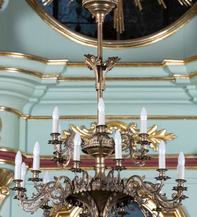 Zdjęcie nr 15: Retabulum ołtarza bocznego charakteryzuje architektoniczna, jednokondygnacyjna, jednoosiowa struktura ze zwieńczeniem. Ołtarz jest drewniany, sarkofagowy z drewnianą mensą. Retabulum osadzone jest na zdwojonym cokole. Część środkowa nastawy ujęta jest parą kolumn i dwoma parami pilastrów, z których jedna ma wklęsłe trzony. Wspomniane elementy wspierają wyłamujące się ponad nimi wklęsło-wypukłe belkowanie. Pole środkowe retabulum jest w kształcie stojącego prostokąta zamkniętego półkolistym łukiem nadwieszonym z uskokami, ujęte jest profilowaną, złoconą ramą. Zwieńczenie, w kształcie stojącego prostokąta zamknięte jest gzymsem w formie nadwieszonego łuku z uskokami. Pole środkowe stanowi owalny prześwit ujęty profilowaną, złoconą ramą. Po bokach zwieńczenia usytuowany jest przerwany, skośnie ustawiony wolutowy przyczółek. Po środku antepedium znajduje się polichromowane gorejące serce Jezusa ujęte gałązkami czerwonej róży. Pola cokołów zdobi ornamentyka rocaille’owo-akantowa. Część środkową retabulum ujmuje para ażurowych uszaków z liści akantu z motywami kogucich grzebieni. Trzony wklęsłych pilastrów w dolnej partii zdobią motywy wolut zwieńczonych liśćmi akantu. W górnej partii trzonów wszystkich pilastrów znajdują się podwieszenia w formie związanych wstążkami kompozycji kwiatowo-owocowych. Kapitele zdobione są detalami ze stylizowanych liści akantu oraz niewielkimi konsolkami z motywem palmety. Fryz dekorują motywy ornamentyki rocaille’owej. Krawędź gzymsu zwieńczenia ujęta jest rodzajem lambrekinu z pojedynczych liści o lancetowatym kształcie. W prześwit wkomponowana została promienista gloria z monogramem Jezusa pośrodku, na ciemnoczerwonym tle, ujęta wieńcem srebrzonych obłoków. W polu części środkowej retabulum znajduje się obraz Najświętsze Serce Jezusa, dodatkowo po bokach, na półkoliście wysuniętych partiach cokołu retabulum usytuowana jest para niewielkich rzeźb św. Rocha i św. Grzegorza Wielkiego. Na przerwanym przyczółku znajduje się para figur aniołów. 
Struktura retabulum utrzymana jest w pastelowym odcieniu turkusu z akcentem ciemnej czerwieni, partie detalu architektonicznego i ornamentyka są złocone i srebrzone.    
