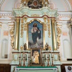 Zdjęcie nr 1: Retabulum ołtarza bocznego charakteryzuje architektoniczna, jednokondygnacyjna, jednoosiowa struktura ze zwieńczeniem. Ołtarz jest drewniany, sarkofagowy z drewnianą mensą. Retabulum osadzone jest na zdwojonym cokole. Część środkowa nastawy ujęta jest parą kolumn i dwoma parami pilastrów, z których jedna ma wklęsłe trzony. Wspomniane elementy wspierają wyłamujące się ponad nimi wklęsło-wypukłe belkowanie. Pole środkowe retabulum jest w kształcie stojącego prostokąta zamkniętego półkolistym łukiem nadwieszonym z uskokami, ujęte jest profilowaną, złoconą ramą. Zwieńczenie, w kształcie stojącego prostokąta zamknięte jest gzymsem w formie nadwieszonego łuku z uskokami. Pole środkowe stanowi owalny prześwit ujęty profilowaną, złoconą ramą. Po bokach zwieńczenia usytuowany jest przerwany, skośnie ustawiony wolutowy przyczółek. Po środku antepedium znajduje się polichromowane gorejące serce Jezusa ujęte gałązkami czerwonej róży. Pola cokołów zdobi ornamentyka rocaille’owo-akantowa. Część środkową retabulum ujmuje para ażurowych uszaków z liści akantu z motywami kogucich grzebieni. Trzony wklęsłych pilastrów w dolnej partii zdobią motywy wolut zwieńczonych liśćmi akantu. W górnej partii trzonów wszystkich pilastrów znajdują się podwieszenia w formie związanych wstążkami kompozycji kwiatowo-owocowych. Kapitele zdobione są detalami ze stylizowanych liści akantu oraz niewielkimi konsolkami z motywem palmety. Fryz dekorują motywy ornamentyki rocaille’owej. Krawędź gzymsu zwieńczenia ujęta jest rodzajem lambrekinu z pojedynczych liści o lancetowatym kształcie. W prześwit wkomponowana została promienista gloria z monogramem Jezusa pośrodku, na ciemnoczerwonym tle, ujęta wieńcem srebrzonych obłoków. W polu części środkowej retabulum znajduje się obraz Najświętsze Serce Jezusa, dodatkowo po bokach, na półkoliście wysuniętych partiach cokołu retabulum usytuowana jest para niewielkich rzeźb św. Rocha i św. Grzegorza Wielkiego. Na przerwanym przyczółku znajduje się para figur aniołów. 
Struktura retabulum utrzymana jest w pastelowym odcieniu turkusu z akcentem ciemnej czerwieni, partie detalu architektonicznego i ornamentyka są złocone i srebrzone.    
