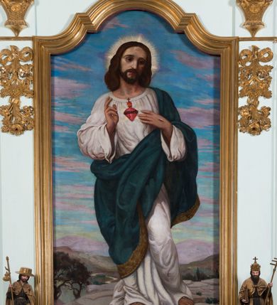 Zdjęcie nr 14: Retabulum ołtarza bocznego charakteryzuje architektoniczna, jednokondygnacyjna, jednoosiowa struktura ze zwieńczeniem. Ołtarz jest drewniany, sarkofagowy z drewnianą mensą. Retabulum osadzone jest na zdwojonym cokole. Część środkowa nastawy ujęta jest parą kolumn i dwoma parami pilastrów, z których jedna ma wklęsłe trzony. Wspomniane elementy wspierają wyłamujące się ponad nimi wklęsło-wypukłe belkowanie. Pole środkowe retabulum jest w kształcie stojącego prostokąta zamkniętego półkolistym łukiem nadwieszonym z uskokami, ujęte jest profilowaną, złoconą ramą. Zwieńczenie, w kształcie stojącego prostokąta zamknięte jest gzymsem w formie nadwieszonego łuku z uskokami. Pole środkowe stanowi owalny prześwit ujęty profilowaną, złoconą ramą. Po bokach zwieńczenia usytuowany jest przerwany, skośnie ustawiony wolutowy przyczółek. Po środku antepedium znajduje się polichromowane gorejące serce Jezusa ujęte gałązkami czerwonej róży. Pola cokołów zdobi ornamentyka rocaille’owo-akantowa. Część środkową retabulum ujmuje para ażurowych uszaków z liści akantu z motywami kogucich grzebieni. Trzony wklęsłych pilastrów w dolnej partii zdobią motywy wolut zwieńczonych liśćmi akantu. W górnej partii trzonów wszystkich pilastrów znajdują się podwieszenia w formie związanych wstążkami kompozycji kwiatowo-owocowych. Kapitele zdobione są detalami ze stylizowanych liści akantu oraz niewielkimi konsolkami z motywem palmety. Fryz dekorują motywy ornamentyki rocaille’owej. Krawędź gzymsu zwieńczenia ujęta jest rodzajem lambrekinu z pojedynczych liści o lancetowatym kształcie. W prześwit wkomponowana została promienista gloria z monogramem Jezusa pośrodku, na ciemnoczerwonym tle, ujęta wieńcem srebrzonych obłoków. W polu części środkowej retabulum znajduje się obraz Najświętsze Serce Jezusa, dodatkowo po bokach, na półkoliście wysuniętych partiach cokołu retabulum usytuowana jest para niewielkich rzeźb św. Rocha i św. Grzegorza Wielkiego. Na przerwanym przyczółku znajduje się para figur aniołów. 
Struktura retabulum utrzymana jest w pastelowym odcieniu turkusu z akcentem ciemnej czerwieni, partie detalu architektonicznego i ornamentyka są złocone i srebrzone.    
