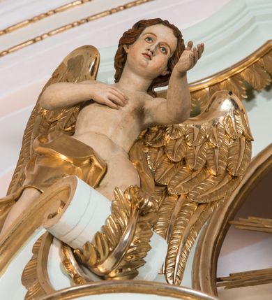 Zdjęcie nr 10: Retabulum ołtarza bocznego charakteryzuje architektoniczna, jednokondygnacyjna, jednoosiowa struktura ze zwieńczeniem. Ołtarz jest drewniany, sarkofagowy z drewnianą mensą. Retabulum osadzone jest na zdwojonym cokole. Część środkowa nastawy ujęta jest parą kolumn i dwoma parami pilastrów, z których jedna ma wklęsłe trzony. Wspomniane elementy wspierają wyłamujące się ponad nimi wklęsło-wypukłe belkowanie. Pole środkowe retabulum jest w kształcie stojącego prostokąta zamkniętego półkolistym łukiem nadwieszonym z uskokami, ujęte jest profilowaną, złoconą ramą. Zwieńczenie, w kształcie stojącego prostokąta zamknięte jest gzymsem w formie nadwieszonego łuku z uskokami. Pole środkowe stanowi owalny prześwit ujęty profilowaną, złoconą ramą. Po bokach zwieńczenia usytuowany jest przerwany, skośnie ustawiony wolutowy przyczółek. Po środku antepedium znajduje się polichromowane gorejące serce Jezusa ujęte gałązkami czerwonej róży. Pola cokołów zdobi ornamentyka rocaille’owo-akantowa. Część środkową retabulum ujmuje para ażurowych uszaków z liści akantu z motywami kogucich grzebieni. Trzony wklęsłych pilastrów w dolnej partii zdobią motywy wolut zwieńczonych liśćmi akantu. W górnej partii trzonów wszystkich pilastrów znajdują się podwieszenia w formie związanych wstążkami kompozycji kwiatowo-owocowych. Kapitele zdobione są detalami ze stylizowanych liści akantu oraz niewielkimi konsolkami z motywem palmety. Fryz dekorują motywy ornamentyki rocaille’owej. Krawędź gzymsu zwieńczenia ujęta jest rodzajem lambrekinu z pojedynczych liści o lancetowatym kształcie. W prześwit wkomponowana została promienista gloria z monogramem Jezusa pośrodku, na ciemnoczerwonym tle, ujęta wieńcem srebrzonych obłoków. W polu części środkowej retabulum znajduje się obraz Najświętsze Serce Jezusa, dodatkowo po bokach, na półkoliście wysuniętych partiach cokołu retabulum usytuowana jest para niewielkich rzeźb św. Rocha i św. Grzegorza Wielkiego. Na przerwanym przyczółku znajduje się para figur aniołów. 
Struktura retabulum utrzymana jest w pastelowym odcieniu turkusu z akcentem ciemnej czerwieni, partie detalu architektonicznego i ornamentyka są złocone i srebrzone.    
