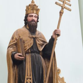 Zdjęcie nr 1: Całopostaciowa, pełnoplastyczna figura przedstawia stojącego na niskiej podstawie św. Grzegorza Wielkiego zwróconego na wprost. Lekko pochyloną głowę charakteryzuje owalna twarz o łagodnych rysach dojrzałego mężczyzny z szeroko rozstawionymi, nieco przymkniętymi oczami, długim, spiczastym nosem oraz długim zarostem. Święty ubrany jest w habit benedyktyński z zawieszoną na ramionach złoconą stułą oraz spiętą na piersiach złoconą kapą. Na głowę nałożona jest tiara papieska. W lewej ręce ma krzyż pontyfikalny, prawą podtrzymuje zamkniętą księgę. Wszystkie insygnia i atrybuty są złocone, zaś polichromia w odsłoniętych partiach ciała naturalistyczna.  