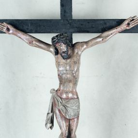 Zdjęcie nr 1: Do prostego krzyża przybita trzema gwoźdźmi pełnoplastyczna figura Chrystusa umarłego. Ciało w lekkim zwisie, o szeroko rozłożonych ramionach, głowa opadająca na prawy bark, nogi delikatnie ugięte w kolanach, stopy w układzie prawa na lewą. Chrystus ma podłużną twarz, z zamkniętymi oczami, długim, spiczastym nosem i wąskimi ustami, okoloną krótką, kręconą brodą. Włosy długie, ciemnobrązowe, silnie skręcone w pukle, opadające na plecy i prawe ramię. Na głowie szeroka korona cierniowa. Ciało szczupłe, o wyraźnie podkreślonej talii i szerokich biodrach, z delikatnie zaznaczoną muskulaturą i żebrami. Perizonium krótkie, odsłaniające prawe udo, zawiązane na prawym biodrze z opadającym wzdłuż nogi zwisem tkaniny. Polichromia ciała naturalistyczna, z zaznaczonymi śladami męki. Na zakończeniu pionowej belki krzyża kartusz z napisem „INRI”.
 

