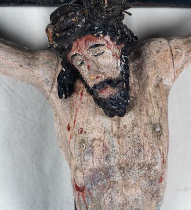 Zdjęcie nr 4: Do prostego krzyża przybita trzema gwoźdźmi pełnoplastyczna figura Chrystusa umarłego. Ciało w lekkim zwisie, o szeroko rozłożonych ramionach, głowa opadająca na prawy bark, nogi delikatnie ugięte w kolanach, stopy w układzie prawa na lewą. Chrystus ma podłużną twarz, z zamkniętymi oczami, długim, spiczastym nosem i wąskimi ustami, okoloną krótką, kręconą brodą. Włosy długie, ciemnobrązowe, silnie skręcone w pukle, opadające na plecy i prawe ramię. Na głowie szeroka korona cierniowa. Ciało szczupłe, o wyraźnie podkreślonej talii i szerokich biodrach, z delikatnie zaznaczoną muskulaturą i żebrami. Perizonium krótkie, odsłaniające prawe udo, zawiązane na prawym biodrze z opadającym wzdłuż nogi zwisem tkaniny. Polichromia ciała naturalistyczna, z zaznaczonymi śladami męki. Na zakończeniu pionowej belki krzyża kartusz z napisem „INRI”.
 
