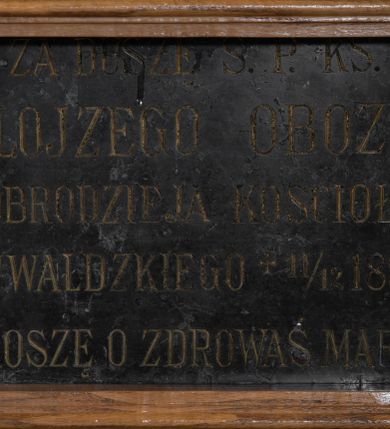 Zdjęcie nr 1: Tablica w kształcie leżącego prostokąta ujęta profilowaną, drewnianą ramą. W polu inskrypcja: „ZA DUSZĘ Ś(WIĘTEJ) P(AMIĘCI) KS(IĘDZA) / ALOJZEGO OBOZY / DOBRODZIEJA KOŚCIOŁA / INWAŁDZKIEGO + 11/12 188(...)/ PROSZĘ O ZDROWAŚ MARIO”.