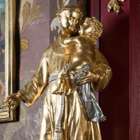 Zdjęcie nr 1: Rzeźba drążona, ustawiona na niskiej podstawie. Święty ukazany frontalnie, z głową skierowaną w lewo, w kontrapoście. Na lewym ramieniu podtrzymuje obejmujące go Dzieciątko Jezus, prawą opuszczoną wyciąga w bok. Twarz ma szczupłą, kwadratową, o podkreślonej linii żuchwy, migdałowatych, blisko siebie osadzonych oczach, małym nosie i rozchylonych ustach. Włosy ma krótkie, kręcone, na głowie tonsura. Święty ubrany jest w habit z kapturem, przepasany podwójnym szczurem ze zwisem z jednym guzem. Dzieciątko zwrócone w trzech czwartych w prawo, rączkami obejmuje głowę świętego, przepasane jest w partii podbrzusza pieluszką. Figury niemal w całości złocone, detale srebrzone.