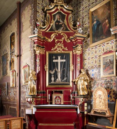 Zdjęcie nr 2: Nastawa architektoniczna, jednoosiowa, jednokondygnacyjna ze zwieńczeniem, na wysokim cokole z wyodrębnionymi konsolami. Ołtarz drewniany, sarkofagowy, na cokole, zwężający się ku dołowi z drewnianą mensą i kamiennym portatylem. Na mensie ustawione tabernakulum w formie prostopadłościennej skrzynki. Ścianka frontowa ujęta ornamentalnymi listewkami; drzwiczki w kształcie stojącego prostokąta w ornamentalnej ramie z płaskorzeźbionym przedstawieniem kielicha z hostią i winnym gronem. Nastawa ujęta parą zdwojonych pilastrów zwróconych pod kątem na zewnątrz, dekorowanych zwisami kwiatowymi, dźwigających silnie wysunięte imposty podtrzymywane przez konsole. Na tle pilastrów figury św. Antoniego Padewskiego i św. Franciszka ustawione na konsolach. W polu środkowym obraz św. Franciszka w formie stojącego prostokąta ujęty profilowaną ramą zdobioną rocaille'em. Powyżej wolutowe fragmenty rocaille'u, pod nim płycina. Zwieńczenie w formie trapezu ujętego spływami wolutowymi, dekorowanymi liśćmi palmowymi, ze ślimacznicami w kształcie meandru, spływającymi na belkowanie, na których stoją wazony. Całość zamknięta fragmentem wyłamanego trójbocznie gzymsu, zwieńczonego rokokowym szczytem z kwiatowymi gałązkami. W polu obraz św. Franciszki Rzymskiej w formie zbliżonej do zwieńczenia, ujęty ramą dekorowaną rocaille'em. Struktura polichromowana w kolorze głębokiej czerwieni, z czarnymi profilami oraz złoconymi ramami, profilami i ornamentyką.
