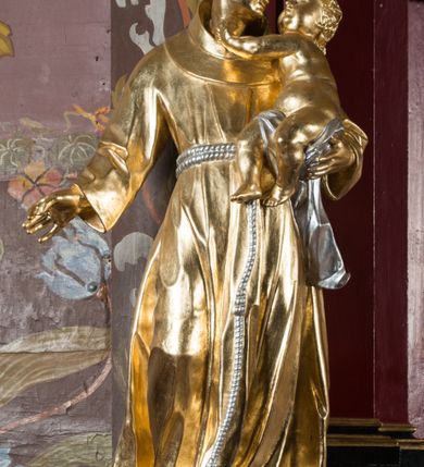 Zdjęcie nr 37: Nastawa architektoniczna, jednoosiowa, jednokondygnacyjna ze zwieńczeniem, na wysokim cokole z wyodrębnionymi konsolami. Ołtarz drewniany, sarkofagowy, na cokole, zwężający się ku dołowi z drewnianą mensą i kamiennym portatylem. Na mensie ustawione tabernakulum w formie prostopadłościennej skrzynki. Ścianka frontowa ujęta ornamentalnymi listewkami; drzwiczki w kształcie stojącego prostokąta w ornamentalnej ramie z płaskorzeźbionym przedstawieniem kielicha z hostią i winnym gronem. Nastawa ujęta parą zdwojonych pilastrów zwróconych pod kątem na zewnątrz, dekorowanych zwisami kwiatowymi, dźwigających silnie wysunięte imposty podtrzymywane przez konsole. Na tle pilastrów figury św. Antoniego Padewskiego i św. Franciszka ustawione na konsolach. W polu środkowym obraz św. Franciszka w formie stojącego prostokąta ujęty profilowaną ramą zdobioną rocaille'em. Powyżej wolutowe fragmenty rocaille'u, pod nim płycina. Zwieńczenie w formie trapezu ujętego spływami wolutowymi, dekorowanymi liśćmi palmowymi, ze ślimacznicami w kształcie meandru, spływającymi na belkowanie, na których stoją wazony. Całość zamknięta fragmentem wyłamanego trójbocznie gzymsu, zwieńczonego rokokowym szczytem z kwiatowymi gałązkami. W polu obraz św. Franciszki Rzymskiej w formie zbliżonej do zwieńczenia, ujęty ramą dekorowaną rocaille'em. Struktura polichromowana w kolorze głębokiej czerwieni, z czarnymi profilami oraz złoconymi ramami, profilami i ornamentyką.
