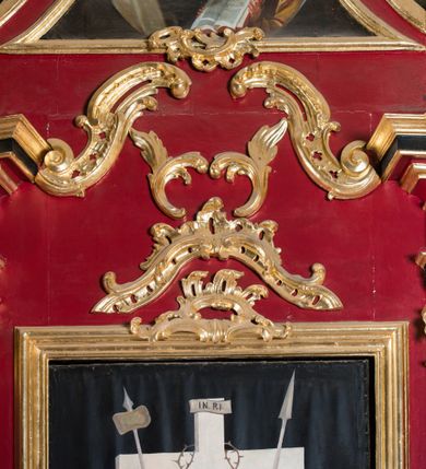 Zdjęcie nr 51: Nastawa architektoniczna, jednoosiowa, jednokondygnacyjna ze zwieńczeniem, na wysokim cokole z wyodrębnionymi konsolami. Ołtarz drewniany, sarkofagowy, na cokole, zwężający się ku dołowi z drewnianą mensą i kamiennym portatylem. Na mensie ustawione tabernakulum w formie prostopadłościennej skrzynki. Ścianka frontowa ujęta ornamentalnymi listewkami; drzwiczki w kształcie stojącego prostokąta w ornamentalnej ramie z płaskorzeźbionym przedstawieniem kielicha z hostią i winnym gronem. Nastawa ujęta parą zdwojonych pilastrów zwróconych pod kątem na zewnątrz, dekorowanych zwisami kwiatowymi, dźwigających silnie wysunięte imposty podtrzymywane przez konsole. Na tle pilastrów figury św. Antoniego Padewskiego i św. Franciszka ustawione na konsolach. W polu środkowym obraz św. Franciszka w formie stojącego prostokąta ujęty profilowaną ramą zdobioną rocaille&#039;em. Powyżej wolutowe fragmenty rocaille&#039;u, pod nim płycina. Zwieńczenie w formie trapezu ujętego spływami wolutowymi, dekorowanymi liśćmi palmowymi, ze ślimacznicami w kształcie meandru, spływającymi na belkowanie, na których stoją wazony. Całość zamknięta fragmentem wyłamanego trójbocznie gzymsu, zwieńczonego rokokowym szczytem z kwiatowymi gałązkami. W polu obraz św. Franciszki Rzymskiej w formie zbliżonej do zwieńczenia, ujęty ramą dekorowaną rocaille&#039;em. Struktura polichromowana w kolorze głębokiej czerwieni, z czarnymi profilami oraz złoconymi ramami, profilami i ornamentyką.
