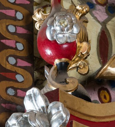 Zdjęcie nr 59: Nastawa architektoniczna, jednoosiowa, jednokondygnacyjna ze zwieńczeniem, na wysokim cokole z wyodrębnionymi konsolami. Ołtarz drewniany, sarkofagowy, na cokole, zwężający się ku dołowi z drewnianą mensą i kamiennym portatylem. Na mensie ustawione tabernakulum w formie prostopadłościennej skrzynki. Ścianka frontowa ujęta ornamentalnymi listewkami; drzwiczki w kształcie stojącego prostokąta w ornamentalnej ramie z płaskorzeźbionym przedstawieniem kielicha z hostią i winnym gronem. Nastawa ujęta parą zdwojonych pilastrów zwróconych pod kątem na zewnątrz, dekorowanych zwisami kwiatowymi, dźwigających silnie wysunięte imposty podtrzymywane przez konsole. Na tle pilastrów figury św. Antoniego Padewskiego i św. Franciszka ustawione na konsolach. W polu środkowym obraz św. Franciszka w formie stojącego prostokąta ujęty profilowaną ramą zdobioną rocaille'em. Powyżej wolutowe fragmenty rocaille'u, pod nim płycina. Zwieńczenie w formie trapezu ujętego spływami wolutowymi, dekorowanymi liśćmi palmowymi, ze ślimacznicami w kształcie meandru, spływającymi na belkowanie, na których stoją wazony. Całość zamknięta fragmentem wyłamanego trójbocznie gzymsu, zwieńczonego rokokowym szczytem z kwiatowymi gałązkami. W polu obraz św. Franciszki Rzymskiej w formie zbliżonej do zwieńczenia, ujęty ramą dekorowaną rocaille'em. Struktura polichromowana w kolorze głębokiej czerwieni, z czarnymi profilami oraz złoconymi ramami, profilami i ornamentyką.
