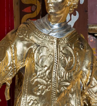 Zdjęcie nr 31: Nastawa architektoniczna, jednoosiowa, jednokondygnacyjna ze zwieńczeniem, na wysokim cokole z wyodrębnionymi konsolami. Ołtarz drewniany, sarkofagowy, na cokole, zwężający się ku dołowi z drewnianą mensą i kamiennym portatylem. Nastawa ujęta parą zdwojonych pilastrów zwróconych pod kątem na zewnątrz, dekorowanych zwisami kwiatowymi, dźwigających silnie wysunięte imposty podtrzymywane przez konsole. Na tle pilastrów figury św. Wawrzyńca i św. Szczepana ustawione na konsolach. Całe pole środkowe wypełnia wtórnie umieszczony obraz „Jezu ufam Tobie” w profilowanej ramie zdobionej rocaille'em. Nad nim fragmenty rocaille'u, pod nim płycina z dekoracją roślinną. Zwieńczenie w formie trapezu ujętego spływami wolutowymi, dekorowanymi liśćmi palmowymi, ze ślimacznicami w kształcie meandru, spływającymi na belkowanie, na których stoją wazony. Całość zamknięta fragmentem wyłamanego trójbocznie gzymsu, zwieńczonego rokokowym szczytem z kwiatowymi gałązkami. W polu obraz św. Wojciecha w formie zbliżonej do zwieńczenia, ujęty ramą dekorowaną rocaille'em. Struktura polichromowana w kolorze głębokiej czerwieni, z czarnymi profilami oraz złoconymi ramami, profilami i ornamentyką.
