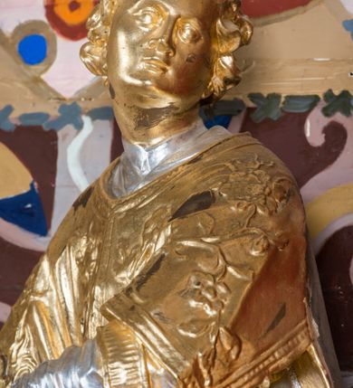 Zdjęcie nr 32: Nastawa architektoniczna, jednoosiowa, jednokondygnacyjna ze zwieńczeniem, na wysokim cokole z wyodrębnionymi konsolami. Ołtarz drewniany, sarkofagowy, na cokole, zwężający się ku dołowi z drewnianą mensą i kamiennym portatylem. Nastawa ujęta parą zdwojonych pilastrów zwróconych pod kątem na zewnątrz, dekorowanych zwisami kwiatowymi, dźwigających silnie wysunięte imposty podtrzymywane przez konsole. Na tle pilastrów figury św. Wawrzyńca i św. Szczepana ustawione na konsolach. Całe pole środkowe wypełnia wtórnie umieszczony obraz „Jezu ufam Tobie” w profilowanej ramie zdobionej rocaille&#039;em. Nad nim fragmenty rocaille&#039;u, pod nim płycina z dekoracją roślinną. Zwieńczenie w formie trapezu ujętego spływami wolutowymi, dekorowanymi liśćmi palmowymi, ze ślimacznicami w kształcie meandru, spływającymi na belkowanie, na których stoją wazony. Całość zamknięta fragmentem wyłamanego trójbocznie gzymsu, zwieńczonego rokokowym szczytem z kwiatowymi gałązkami. W polu obraz św. Wojciecha w formie zbliżonej do zwieńczenia, ujęty ramą dekorowaną rocaille&#039;em. Struktura polichromowana w kolorze głębokiej czerwieni, z czarnymi profilami oraz złoconymi ramami, profilami i ornamentyką.
