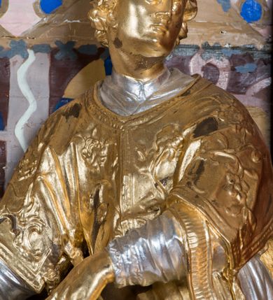 Zdjęcie nr 3: Nastawa architektoniczna, jednoosiowa, jednokondygnacyjna ze zwieńczeniem, na wysokim cokole z wyodrębnionymi konsolami. Ołtarz drewniany, sarkofagowy, na cokole, zwężający się ku dołowi z drewnianą mensą i kamiennym portatylem. Nastawa ujęta parą zdwojonych pilastrów zwróconych pod kątem na zewnątrz, dekorowanych zwisami kwiatowymi, dźwigających silnie wysunięte imposty podtrzymywane przez konsole. Na tle pilastrów figury św. Wawrzyńca i św. Szczepana ustawione na konsolach. Całe pole środkowe wypełnia wtórnie umieszczony obraz „Jezu ufam Tobie” w profilowanej ramie zdobionej rocaille'em. Nad nim fragmenty rocaille'u, pod nim płycina z dekoracją roślinną. Zwieńczenie w formie trapezu ujętego spływami wolutowymi, dekorowanymi liśćmi palmowymi, ze ślimacznicami w kształcie meandru, spływającymi na belkowanie, na których stoją wazony. Całość zamknięta fragmentem wyłamanego trójbocznie gzymsu, zwieńczonego rokokowym szczytem z kwiatowymi gałązkami. W polu obraz św. Wojciecha w formie zbliżonej do zwieńczenia, ujęty ramą dekorowaną rocaille'em. Struktura polichromowana w kolorze głębokiej czerwieni, z czarnymi profilami oraz złoconymi ramami, profilami i ornamentyką.
