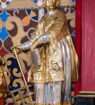 Zdjęcie nr 5: Nastawa architektoniczna, jednoosiowa, jednokondygnacyjna ze zwieńczeniem, na wysokim cokole z wyodrębnionymi konsolami. Ołtarz drewniany, sarkofagowy, na cokole, zwężający się ku dołowi z drewnianą mensą i kamiennym portatylem. Nastawa ujęta parą zdwojonych pilastrów zwróconych pod kątem na zewnątrz, dekorowanych zwisami kwiatowymi, dźwigających silnie wysunięte imposty podtrzymywane przez konsole. Na tle pilastrów figury św. Wawrzyńca i św. Szczepana ustawione na konsolach. Całe pole środkowe wypełnia wtórnie umieszczony obraz „Jezu ufam Tobie” w profilowanej ramie zdobionej rocaille&#039;em. Nad nim fragmenty rocaille&#039;u, pod nim płycina z dekoracją roślinną. Zwieńczenie w formie trapezu ujętego spływami wolutowymi, dekorowanymi liśćmi palmowymi, ze ślimacznicami w kształcie meandru, spływającymi na belkowanie, na których stoją wazony. Całość zamknięta fragmentem wyłamanego trójbocznie gzymsu, zwieńczonego rokokowym szczytem z kwiatowymi gałązkami. W polu obraz św. Wojciecha w formie zbliżonej do zwieńczenia, ujęty ramą dekorowaną rocaille&#039;em. Struktura polichromowana w kolorze głębokiej czerwieni, z czarnymi profilami oraz złoconymi ramami, profilami i ornamentyką.
