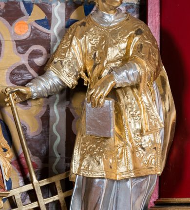 Zdjęcie nr 8: Nastawa architektoniczna, jednoosiowa, jednokondygnacyjna ze zwieńczeniem, na wysokim cokole z wyodrębnionymi konsolami. Ołtarz drewniany, sarkofagowy, na cokole, zwężający się ku dołowi z drewnianą mensą i kamiennym portatylem. Nastawa ujęta parą zdwojonych pilastrów zwróconych pod kątem na zewnątrz, dekorowanych zwisami kwiatowymi, dźwigających silnie wysunięte imposty podtrzymywane przez konsole. Na tle pilastrów figury św. Wawrzyńca i św. Szczepana ustawione na konsolach. Całe pole środkowe wypełnia wtórnie umieszczony obraz „Jezu ufam Tobie” w profilowanej ramie zdobionej rocaille'em. Nad nim fragmenty rocaille'u, pod nim płycina z dekoracją roślinną. Zwieńczenie w formie trapezu ujętego spływami wolutowymi, dekorowanymi liśćmi palmowymi, ze ślimacznicami w kształcie meandru, spływającymi na belkowanie, na których stoją wazony. Całość zamknięta fragmentem wyłamanego trójbocznie gzymsu, zwieńczonego rokokowym szczytem z kwiatowymi gałązkami. W polu obraz św. Wojciecha w formie zbliżonej do zwieńczenia, ujęty ramą dekorowaną rocaille'em. Struktura polichromowana w kolorze głębokiej czerwieni, z czarnymi profilami oraz złoconymi ramami, profilami i ornamentyką.
