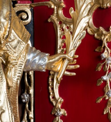 Zdjęcie nr 20: Nastawa architektoniczna, jednoosiowa, jednokondygnacyjna ze zwieńczeniem, na wysokim cokole z wyodrębnionymi konsolami. Ołtarz drewniany, sarkofagowy, na cokole, zwężający się ku dołowi z drewnianą mensą i kamiennym portatylem. Nastawa ujęta parą zdwojonych pilastrów zwróconych pod kątem na zewnątrz, dekorowanych zwisami kwiatowymi, dźwigających silnie wysunięte imposty podtrzymywane przez konsole. Na tle pilastrów figury św. Wawrzyńca i św. Szczepana ustawione na konsolach. Całe pole środkowe wypełnia wtórnie umieszczony obraz „Jezu ufam Tobie” w profilowanej ramie zdobionej rocaille'em. Nad nim fragmenty rocaille'u, pod nim płycina z dekoracją roślinną. Zwieńczenie w formie trapezu ujętego spływami wolutowymi, dekorowanymi liśćmi palmowymi, ze ślimacznicami w kształcie meandru, spływającymi na belkowanie, na których stoją wazony. Całość zamknięta fragmentem wyłamanego trójbocznie gzymsu, zwieńczonego rokokowym szczytem z kwiatowymi gałązkami. W polu obraz św. Wojciecha w formie zbliżonej do zwieńczenia, ujęty ramą dekorowaną rocaille'em. Struktura polichromowana w kolorze głębokiej czerwieni, z czarnymi profilami oraz złoconymi ramami, profilami i ornamentyką.
