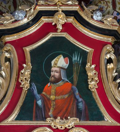 Zdjęcie nr 23: Nastawa architektoniczna, jednoosiowa, jednokondygnacyjna ze zwieńczeniem, na wysokim cokole z wyodrębnionymi konsolami. Ołtarz drewniany, sarkofagowy, na cokole, zwężający się ku dołowi z drewnianą mensą i kamiennym portatylem. Nastawa ujęta parą zdwojonych pilastrów zwróconych pod kątem na zewnątrz, dekorowanych zwisami kwiatowymi, dźwigających silnie wysunięte imposty podtrzymywane przez konsole. Na tle pilastrów figury św. Wawrzyńca i św. Szczepana ustawione na konsolach. Całe pole środkowe wypełnia wtórnie umieszczony obraz „Jezu ufam Tobie” w profilowanej ramie zdobionej rocaille'em. Nad nim fragmenty rocaille'u, pod nim płycina z dekoracją roślinną. Zwieńczenie w formie trapezu ujętego spływami wolutowymi, dekorowanymi liśćmi palmowymi, ze ślimacznicami w kształcie meandru, spływającymi na belkowanie, na których stoją wazony. Całość zamknięta fragmentem wyłamanego trójbocznie gzymsu, zwieńczonego rokokowym szczytem z kwiatowymi gałązkami. W polu obraz św. Wojciecha w formie zbliżonej do zwieńczenia, ujęty ramą dekorowaną rocaille'em. Struktura polichromowana w kolorze głębokiej czerwieni, z czarnymi profilami oraz złoconymi ramami, profilami i ornamentyką.
