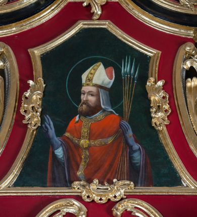 Zdjęcie nr 22: Nastawa architektoniczna, jednoosiowa, jednokondygnacyjna ze zwieńczeniem, na wysokim cokole z wyodrębnionymi konsolami. Ołtarz drewniany, sarkofagowy, na cokole, zwężający się ku dołowi z drewnianą mensą i kamiennym portatylem. Nastawa ujęta parą zdwojonych pilastrów zwróconych pod kątem na zewnątrz, dekorowanych zwisami kwiatowymi, dźwigających silnie wysunięte imposty podtrzymywane przez konsole. Na tle pilastrów figury św. Wawrzyńca i św. Szczepana ustawione na konsolach. Całe pole środkowe wypełnia wtórnie umieszczony obraz „Jezu ufam Tobie” w profilowanej ramie zdobionej rocaille'em. Nad nim fragmenty rocaille'u, pod nim płycina z dekoracją roślinną. Zwieńczenie w formie trapezu ujętego spływami wolutowymi, dekorowanymi liśćmi palmowymi, ze ślimacznicami w kształcie meandru, spływającymi na belkowanie, na których stoją wazony. Całość zamknięta fragmentem wyłamanego trójbocznie gzymsu, zwieńczonego rokokowym szczytem z kwiatowymi gałązkami. W polu obraz św. Wojciecha w formie zbliżonej do zwieńczenia, ujęty ramą dekorowaną rocaille'em. Struktura polichromowana w kolorze głębokiej czerwieni, z czarnymi profilami oraz złoconymi ramami, profilami i ornamentyką.
