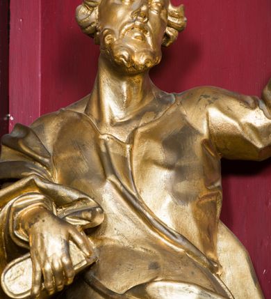 Zdjęcie nr 34: Nastawa architektoniczna, jednoosiowa, jednokondygnacyjna ze zwieńczeniem, ustawiona na dwustrefowym cokole z wyodrębnionymi prostopadłościanami. Ołtarz drewniany, prostopadłościenny z drewnianą mensą. Antepedium wydzielone ramą i wysunięte do przodu, ujęte pilastrami dźwigającymi niepełne belkowanie, w polu wieniec laurowy z rozetą, nad nim kokarda z karbowanej wstęgi flankowana przez dwa podwieszone festony z tkaniny, poniżej wić roślinna. Na ołtarzu ustawione tabernakulum w formie metalowej skrzynki w drewnianej obudowie, ujęte ustawionymi pod kątem spływami wolutowymi. Ścianka frontowa wypukła, z drewnianymi drzwiczkami w kształcie stojącego prostokąta zamkniętego łukiem półkolistym z płaskorzeźbionym kielichem z hostią i kłosami zbóż. Na nim wysoki tron wystawienia z wypukłym frontem z zamontowanym wtórnie nowym tabernakulum (wcześniej obrotowa nisza). Tron ujęty pilastrami ustawionymi pod kątem, o trzonach przechodzących w spływy wolutowe, dekorowane zwisami kwiatowymi; zwieńczony jest trzema rocaille'owymi kabłąkami dekorowanymi zwisami kwiatowymi, podtrzymującymi figurkę pelikana karmiącego młode w gnieździe. Tabernakulum i tron flankowane spływami z podwieszonymi zwisami kwiatowymi zakończonymi cokołami, dźwigającymi przerwany wolutowy przyczółek z figurkami adorujących aniołów; spływy w górnej części zamknięte fragmentami gzymsu z palmetami. 
Nastawa ujęta dwiema parami pilastrów oraz stojącą na ich tle parą kolumn na cokołach dźwigających pełne belkowanie przerwane nad polem środkowym oraz fragmenty przerwanego, wolutowego przyczółka. Przed wewnętrzną parą pilastrów ustawione figury św. Piotra i św. Pawła; na belkowaniu wazony, na przyczółku putta trzymające słońce i księżyc. W polu środkowym podwójna wnęka w formie stojącego prostokąta zamkniętego łukiem odcinkowym nadwieszonym, ujęta profilowaną ramą, ze znacznie mniejszym obrazem Matki Boskiej w kształcie stojącego prostokąta. Nad nią medalion utworzony z wolut i zwisów, zwieńczony koroną otwartą. Zwieńczenie nastawy w formie trapezu ujętego wolutami spływającymi na belkowanie, zamknięte fragmentem falistego gzymsu, dekorowanym medalionem z Okiem Opatrzności w otoku z obłoków w glorii promienistej oraz gałązkami kwiatowymi. W polu obraz św. Katarzyny w formie zbliżonej do zwieńczenia, o ściętych dolnych narożach, w profilowanej ramie, z gałązkami kwiatowymi. 
Nastawa flankowana uszami utworzonymi z rocaille'u, przytwierdzonymi do ściany. Ujęta parą wsporników na trumienki relikwiarzowe oraz parą dużych konsol dekorowanych rocaille'm z figurami św. Mikołaja i św. Stanisława. Struktura polichromowana w kolorze głębokiej czerwieni z czarnymi profilami; kolumny, ornamentyka i profile złocone i srebrzone.