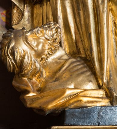 Zdjęcie nr 53: Nastawa architektoniczna, jednoosiowa, jednokondygnacyjna ze zwieńczeniem, ustawiona na dwustrefowym cokole z wyodrębnionymi prostopadłościanami. Ołtarz drewniany, prostopadłościenny z drewnianą mensą. Antepedium wydzielone ramą i wysunięte do przodu, ujęte pilastrami dźwigającymi niepełne belkowanie, w polu wieniec laurowy z rozetą, nad nim kokarda z karbowanej wstęgi flankowana przez dwa podwieszone festony z tkaniny, poniżej wić roślinna. Na ołtarzu ustawione tabernakulum w formie metalowej skrzynki w drewnianej obudowie, ujęte ustawionymi pod kątem spływami wolutowymi. Ścianka frontowa wypukła, z drewnianymi drzwiczkami w kształcie stojącego prostokąta zamkniętego łukiem półkolistym z płaskorzeźbionym kielichem z hostią i kłosami zbóż. Na nim wysoki tron wystawienia z wypukłym frontem z zamontowanym wtórnie nowym tabernakulum (wcześniej obrotowa nisza). Tron ujęty pilastrami ustawionymi pod kątem, o trzonach przechodzących w spływy wolutowe, dekorowane zwisami kwiatowymi; zwieńczony jest trzema rocaille&#039;owymi kabłąkami dekorowanymi zwisami kwiatowymi, podtrzymującymi figurkę pelikana karmiącego młode w gnieździe. Tabernakulum i tron flankowane spływami z podwieszonymi zwisami kwiatowymi zakończonymi cokołami, dźwigającymi przerwany wolutowy przyczółek z figurkami adorujących aniołów; spływy w górnej części zamknięte fragmentami gzymsu z palmetami. 
Nastawa ujęta dwiema parami pilastrów oraz stojącą na ich tle parą kolumn na cokołach dźwigających pełne belkowanie przerwane nad polem środkowym oraz fragmenty przerwanego, wolutowego przyczółka. Przed wewnętrzną parą pilastrów ustawione figury św. Piotra i św. Pawła; na belkowaniu wazony, na przyczółku putta trzymające słońce i księżyc. W polu środkowym podwójna wnęka w formie stojącego prostokąta zamkniętego łukiem odcinkowym nadwieszonym, ujęta profilowaną ramą, ze znacznie mniejszym obrazem Matki Boskiej w kształcie stojącego prostokąta. Nad nią medalion utworzony z wolut i zwisów, zwieńczony koroną otwartą. Zwieńczenie nastawy w formie trapezu ujętego wolutami spływającymi na belkowanie, zamknięte fragmentem falistego gzymsu, dekorowanym medalionem z Okiem Opatrzności w otoku z obłoków w glorii promienistej oraz gałązkami kwiatowymi. W polu obraz św. Katarzyny w formie zbliżonej do zwieńczenia, o ściętych dolnych narożach, w profilowanej ramie, z gałązkami kwiatowymi. 
Nastawa flankowana uszami utworzonymi z rocaille&#039;u, przytwierdzonymi do ściany. Ujęta parą wsporników na trumienki relikwiarzowe oraz parą dużych konsol dekorowanych rocaille&#039;m z figurami św. Mikołaja i św. Stanisława. Struktura polichromowana w kolorze głębokiej czerwieni z czarnymi profilami; kolumny, ornamentyka i profile złocone i srebrzone.