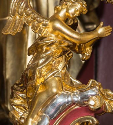 Zdjęcie nr 62: Nastawa architektoniczna, jednoosiowa, jednokondygnacyjna ze zwieńczeniem, ustawiona na dwustrefowym cokole z wyodrębnionymi prostopadłościanami. Ołtarz drewniany, prostopadłościenny z drewnianą mensą. Antepedium wydzielone ramą i wysunięte do przodu, ujęte pilastrami dźwigającymi niepełne belkowanie, w polu wieniec laurowy z rozetą, nad nim kokarda z karbowanej wstęgi flankowana przez dwa podwieszone festony z tkaniny, poniżej wić roślinna. Na ołtarzu ustawione tabernakulum w formie metalowej skrzynki w drewnianej obudowie, ujęte ustawionymi pod kątem spływami wolutowymi. Ścianka frontowa wypukła, z drewnianymi drzwiczkami w kształcie stojącego prostokąta zamkniętego łukiem półkolistym z płaskorzeźbionym kielichem z hostią i kłosami zbóż. Na nim wysoki tron wystawienia z wypukłym frontem z zamontowanym wtórnie nowym tabernakulum (wcześniej obrotowa nisza). Tron ujęty pilastrami ustawionymi pod kątem, o trzonach przechodzących w spływy wolutowe, dekorowane zwisami kwiatowymi; zwieńczony jest trzema rocaille&#039;owymi kabłąkami dekorowanymi zwisami kwiatowymi, podtrzymującymi figurkę pelikana karmiącego młode w gnieździe. Tabernakulum i tron flankowane spływami z podwieszonymi zwisami kwiatowymi zakończonymi cokołami, dźwigającymi przerwany wolutowy przyczółek z figurkami adorujących aniołów; spływy w górnej części zamknięte fragmentami gzymsu z palmetami. 
Nastawa ujęta dwiema parami pilastrów oraz stojącą na ich tle parą kolumn na cokołach dźwigających pełne belkowanie przerwane nad polem środkowym oraz fragmenty przerwanego, wolutowego przyczółka. Przed wewnętrzną parą pilastrów ustawione figury św. Piotra i św. Pawła; na belkowaniu wazony, na przyczółku putta trzymające słońce i księżyc. W polu środkowym podwójna wnęka w formie stojącego prostokąta zamkniętego łukiem odcinkowym nadwieszonym, ujęta profilowaną ramą, ze znacznie mniejszym obrazem Matki Boskiej w kształcie stojącego prostokąta. Nad nią medalion utworzony z wolut i zwisów, zwieńczony koroną otwartą. Zwieńczenie nastawy w formie trapezu ujętego wolutami spływającymi na belkowanie, zamknięte fragmentem falistego gzymsu, dekorowanym medalionem z Okiem Opatrzności w otoku z obłoków w glorii promienistej oraz gałązkami kwiatowymi. W polu obraz św. Katarzyny w formie zbliżonej do zwieńczenia, o ściętych dolnych narożach, w profilowanej ramie, z gałązkami kwiatowymi. 
Nastawa flankowana uszami utworzonymi z rocaille&#039;u, przytwierdzonymi do ściany. Ujęta parą wsporników na trumienki relikwiarzowe oraz parą dużych konsol dekorowanych rocaille&#039;m z figurami św. Mikołaja i św. Stanisława. Struktura polichromowana w kolorze głębokiej czerwieni z czarnymi profilami; kolumny, ornamentyka i profile złocone i srebrzone.