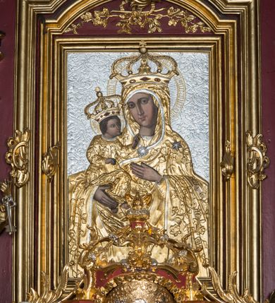 Zdjęcie nr 46: Nastawa architektoniczna, jednoosiowa, jednokondygnacyjna ze zwieńczeniem, ustawiona na dwustrefowym cokole z wyodrębnionymi prostopadłościanami. Ołtarz drewniany, prostopadłościenny z drewnianą mensą. Antepedium wydzielone ramą i wysunięte do przodu, ujęte pilastrami dźwigającymi niepełne belkowanie, w polu wieniec laurowy z rozetą, nad nim kokarda z karbowanej wstęgi flankowana przez dwa podwieszone festony z tkaniny, poniżej wić roślinna. Na ołtarzu ustawione tabernakulum w formie metalowej skrzynki w drewnianej obudowie, ujęte ustawionymi pod kątem spływami wolutowymi. Ścianka frontowa wypukła, z drewnianymi drzwiczkami w kształcie stojącego prostokąta zamkniętego łukiem półkolistym z płaskorzeźbionym kielichem z hostią i kłosami zbóż. Na nim wysoki tron wystawienia z wypukłym frontem z zamontowanym wtórnie nowym tabernakulum (wcześniej obrotowa nisza). Tron ujęty pilastrami ustawionymi pod kątem, o trzonach przechodzących w spływy wolutowe, dekorowane zwisami kwiatowymi; zwieńczony jest trzema rocaille&#039;owymi kabłąkami dekorowanymi zwisami kwiatowymi, podtrzymującymi figurkę pelikana karmiącego młode w gnieździe. Tabernakulum i tron flankowane spływami z podwieszonymi zwisami kwiatowymi zakończonymi cokołami, dźwigającymi przerwany wolutowy przyczółek z figurkami adorujących aniołów; spływy w górnej części zamknięte fragmentami gzymsu z palmetami. 
Nastawa ujęta dwiema parami pilastrów oraz stojącą na ich tle parą kolumn na cokołach dźwigających pełne belkowanie przerwane nad polem środkowym oraz fragmenty przerwanego, wolutowego przyczółka. Przed wewnętrzną parą pilastrów ustawione figury św. Piotra i św. Pawła; na belkowaniu wazony, na przyczółku putta trzymające słońce i księżyc. W polu środkowym podwójna wnęka w formie stojącego prostokąta zamkniętego łukiem odcinkowym nadwieszonym, ujęta profilowaną ramą, ze znacznie mniejszym obrazem Matki Boskiej w kształcie stojącego prostokąta. Nad nią medalion utworzony z wolut i zwisów, zwieńczony koroną otwartą. Zwieńczenie nastawy w formie trapezu ujętego wolutami spływającymi na belkowanie, zamknięte fragmentem falistego gzymsu, dekorowanym medalionem z Okiem Opatrzności w otoku z obłoków w glorii promienistej oraz gałązkami kwiatowymi. W polu obraz św. Katarzyny w formie zbliżonej do zwieńczenia, o ściętych dolnych narożach, w profilowanej ramie, z gałązkami kwiatowymi. 
Nastawa flankowana uszami utworzonymi z rocaille&#039;u, przytwierdzonymi do ściany. Ujęta parą wsporników na trumienki relikwiarzowe oraz parą dużych konsol dekorowanych rocaille&#039;m z figurami św. Mikołaja i św. Stanisława. Struktura polichromowana w kolorze głębokiej czerwieni z czarnymi profilami; kolumny, ornamentyka i profile złocone i srebrzone.