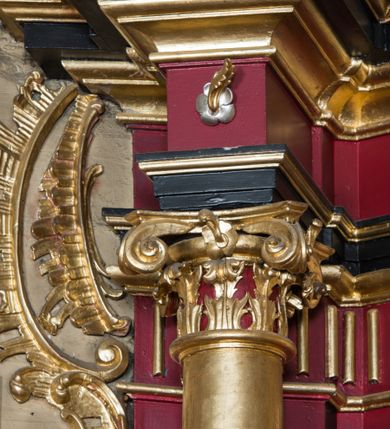 Zdjęcie nr 64: Nastawa architektoniczna, jednoosiowa, jednokondygnacyjna ze zwieńczeniem, ustawiona na dwustrefowym cokole z wyodrębnionymi prostopadłościanami. Ołtarz drewniany, prostopadłościenny z drewnianą mensą. Antepedium wydzielone ramą i wysunięte do przodu, ujęte pilastrami dźwigającymi niepełne belkowanie, w polu wieniec laurowy z rozetą, nad nim kokarda z karbowanej wstęgi flankowana przez dwa podwieszone festony z tkaniny, poniżej wić roślinna. Na ołtarzu ustawione tabernakulum w formie metalowej skrzynki w drewnianej obudowie, ujęte ustawionymi pod kątem spływami wolutowymi. Ścianka frontowa wypukła, z drewnianymi drzwiczkami w kształcie stojącego prostokąta zamkniętego łukiem półkolistym z płaskorzeźbionym kielichem z hostią i kłosami zbóż. Na nim wysoki tron wystawienia z wypukłym frontem z zamontowanym wtórnie nowym tabernakulum (wcześniej obrotowa nisza). Tron ujęty pilastrami ustawionymi pod kątem, o trzonach przechodzących w spływy wolutowe, dekorowane zwisami kwiatowymi; zwieńczony jest trzema rocaille'owymi kabłąkami dekorowanymi zwisami kwiatowymi, podtrzymującymi figurkę pelikana karmiącego młode w gnieździe. Tabernakulum i tron flankowane spływami z podwieszonymi zwisami kwiatowymi zakończonymi cokołami, dźwigającymi przerwany wolutowy przyczółek z figurkami adorujących aniołów; spływy w górnej części zamknięte fragmentami gzymsu z palmetami. 
Nastawa ujęta dwiema parami pilastrów oraz stojącą na ich tle parą kolumn na cokołach dźwigających pełne belkowanie przerwane nad polem środkowym oraz fragmenty przerwanego, wolutowego przyczółka. Przed wewnętrzną parą pilastrów ustawione figury św. Piotra i św. Pawła; na belkowaniu wazony, na przyczółku putta trzymające słońce i księżyc. W polu środkowym podwójna wnęka w formie stojącego prostokąta zamkniętego łukiem odcinkowym nadwieszonym, ujęta profilowaną ramą, ze znacznie mniejszym obrazem Matki Boskiej w kształcie stojącego prostokąta. Nad nią medalion utworzony z wolut i zwisów, zwieńczony koroną otwartą. Zwieńczenie nastawy w formie trapezu ujętego wolutami spływającymi na belkowanie, zamknięte fragmentem falistego gzymsu, dekorowanym medalionem z Okiem Opatrzności w otoku z obłoków w glorii promienistej oraz gałązkami kwiatowymi. W polu obraz św. Katarzyny w formie zbliżonej do zwieńczenia, o ściętych dolnych narożach, w profilowanej ramie, z gałązkami kwiatowymi. 
Nastawa flankowana uszami utworzonymi z rocaille'u, przytwierdzonymi do ściany. Ujęta parą wsporników na trumienki relikwiarzowe oraz parą dużych konsol dekorowanych rocaille'm z figurami św. Mikołaja i św. Stanisława. Struktura polichromowana w kolorze głębokiej czerwieni z czarnymi profilami; kolumny, ornamentyka i profile złocone i srebrzone.