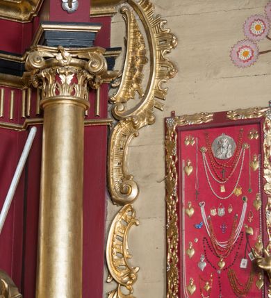 Zdjęcie nr 66: Nastawa architektoniczna, jednoosiowa, jednokondygnacyjna ze zwieńczeniem, ustawiona na dwustrefowym cokole z wyodrębnionymi prostopadłościanami. Ołtarz drewniany, prostopadłościenny z drewnianą mensą. Antepedium wydzielone ramą i wysunięte do przodu, ujęte pilastrami dźwigającymi niepełne belkowanie, w polu wieniec laurowy z rozetą, nad nim kokarda z karbowanej wstęgi flankowana przez dwa podwieszone festony z tkaniny, poniżej wić roślinna. Na ołtarzu ustawione tabernakulum w formie metalowej skrzynki w drewnianej obudowie, ujęte ustawionymi pod kątem spływami wolutowymi. Ścianka frontowa wypukła, z drewnianymi drzwiczkami w kształcie stojącego prostokąta zamkniętego łukiem półkolistym z płaskorzeźbionym kielichem z hostią i kłosami zbóż. Na nim wysoki tron wystawienia z wypukłym frontem z zamontowanym wtórnie nowym tabernakulum (wcześniej obrotowa nisza). Tron ujęty pilastrami ustawionymi pod kątem, o trzonach przechodzących w spływy wolutowe, dekorowane zwisami kwiatowymi; zwieńczony jest trzema rocaille'owymi kabłąkami dekorowanymi zwisami kwiatowymi, podtrzymującymi figurkę pelikana karmiącego młode w gnieździe. Tabernakulum i tron flankowane spływami z podwieszonymi zwisami kwiatowymi zakończonymi cokołami, dźwigającymi przerwany wolutowy przyczółek z figurkami adorujących aniołów; spływy w górnej części zamknięte fragmentami gzymsu z palmetami. 
Nastawa ujęta dwiema parami pilastrów oraz stojącą na ich tle parą kolumn na cokołach dźwigających pełne belkowanie przerwane nad polem środkowym oraz fragmenty przerwanego, wolutowego przyczółka. Przed wewnętrzną parą pilastrów ustawione figury św. Piotra i św. Pawła; na belkowaniu wazony, na przyczółku putta trzymające słońce i księżyc. W polu środkowym podwójna wnęka w formie stojącego prostokąta zamkniętego łukiem odcinkowym nadwieszonym, ujęta profilowaną ramą, ze znacznie mniejszym obrazem Matki Boskiej w kształcie stojącego prostokąta. Nad nią medalion utworzony z wolut i zwisów, zwieńczony koroną otwartą. Zwieńczenie nastawy w formie trapezu ujętego wolutami spływającymi na belkowanie, zamknięte fragmentem falistego gzymsu, dekorowanym medalionem z Okiem Opatrzności w otoku z obłoków w glorii promienistej oraz gałązkami kwiatowymi. W polu obraz św. Katarzyny w formie zbliżonej do zwieńczenia, o ściętych dolnych narożach, w profilowanej ramie, z gałązkami kwiatowymi. 
Nastawa flankowana uszami utworzonymi z rocaille'u, przytwierdzonymi do ściany. Ujęta parą wsporników na trumienki relikwiarzowe oraz parą dużych konsol dekorowanych rocaille'm z figurami św. Mikołaja i św. Stanisława. Struktura polichromowana w kolorze głębokiej czerwieni z czarnymi profilami; kolumny, ornamentyka i profile złocone i srebrzone.