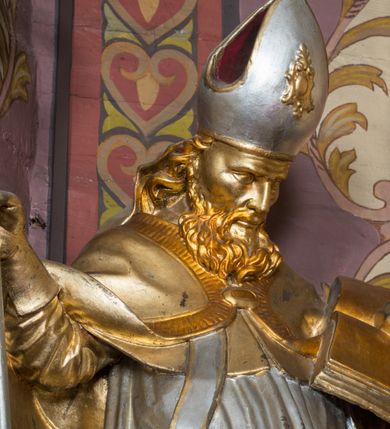 Zdjęcie nr 73: Nastawa architektoniczna, jednoosiowa, jednokondygnacyjna ze zwieńczeniem, ustawiona na dwustrefowym cokole z wyodrębnionymi prostopadłościanami. Ołtarz drewniany, prostopadłościenny z drewnianą mensą. Antepedium wydzielone ramą i wysunięte do przodu, ujęte pilastrami dźwigającymi niepełne belkowanie, w polu wieniec laurowy z rozetą, nad nim kokarda z karbowanej wstęgi flankowana przez dwa podwieszone festony z tkaniny, poniżej wić roślinna. Na ołtarzu ustawione tabernakulum w formie metalowej skrzynki w drewnianej obudowie, ujęte ustawionymi pod kątem spływami wolutowymi. Ścianka frontowa wypukła, z drewnianymi drzwiczkami w kształcie stojącego prostokąta zamkniętego łukiem półkolistym z płaskorzeźbionym kielichem z hostią i kłosami zbóż. Na nim wysoki tron wystawienia z wypukłym frontem z zamontowanym wtórnie nowym tabernakulum (wcześniej obrotowa nisza). Tron ujęty pilastrami ustawionymi pod kątem, o trzonach przechodzących w spływy wolutowe, dekorowane zwisami kwiatowymi; zwieńczony jest trzema rocaille'owymi kabłąkami dekorowanymi zwisami kwiatowymi, podtrzymującymi figurkę pelikana karmiącego młode w gnieździe. Tabernakulum i tron flankowane spływami z podwieszonymi zwisami kwiatowymi zakończonymi cokołami, dźwigającymi przerwany wolutowy przyczółek z figurkami adorujących aniołów; spływy w górnej części zamknięte fragmentami gzymsu z palmetami. 
Nastawa ujęta dwiema parami pilastrów oraz stojącą na ich tle parą kolumn na cokołach dźwigających pełne belkowanie przerwane nad polem środkowym oraz fragmenty przerwanego, wolutowego przyczółka. Przed wewnętrzną parą pilastrów ustawione figury św. Piotra i św. Pawła; na belkowaniu wazony, na przyczółku putta trzymające słońce i księżyc. W polu środkowym podwójna wnęka w formie stojącego prostokąta zamkniętego łukiem odcinkowym nadwieszonym, ujęta profilowaną ramą, ze znacznie mniejszym obrazem Matki Boskiej w kształcie stojącego prostokąta. Nad nią medalion utworzony z wolut i zwisów, zwieńczony koroną otwartą. Zwieńczenie nastawy w formie trapezu ujętego wolutami spływającymi na belkowanie, zamknięte fragmentem falistego gzymsu, dekorowanym medalionem z Okiem Opatrzności w otoku z obłoków w glorii promienistej oraz gałązkami kwiatowymi. W polu obraz św. Katarzyny w formie zbliżonej do zwieńczenia, o ściętych dolnych narożach, w profilowanej ramie, z gałązkami kwiatowymi. 
Nastawa flankowana uszami utworzonymi z rocaille'u, przytwierdzonymi do ściany. Ujęta parą wsporników na trumienki relikwiarzowe oraz parą dużych konsol dekorowanych rocaille'm z figurami św. Mikołaja i św. Stanisława. Struktura polichromowana w kolorze głębokiej czerwieni z czarnymi profilami; kolumny, ornamentyka i profile złocone i srebrzone.