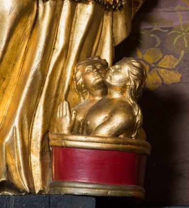 Zdjęcie nr 82: Nastawa architektoniczna, jednoosiowa, jednokondygnacyjna ze zwieńczeniem, ustawiona na dwustrefowym cokole z wyodrębnionymi prostopadłościanami. Ołtarz drewniany, prostopadłościenny z drewnianą mensą. Antepedium wydzielone ramą i wysunięte do przodu, ujęte pilastrami dźwigającymi niepełne belkowanie, w polu wieniec laurowy z rozetą, nad nim kokarda z karbowanej wstęgi flankowana przez dwa podwieszone festony z tkaniny, poniżej wić roślinna. Na ołtarzu ustawione tabernakulum w formie metalowej skrzynki w drewnianej obudowie, ujęte ustawionymi pod kątem spływami wolutowymi. Ścianka frontowa wypukła, z drewnianymi drzwiczkami w kształcie stojącego prostokąta zamkniętego łukiem półkolistym z płaskorzeźbionym kielichem z hostią i kłosami zbóż. Na nim wysoki tron wystawienia z wypukłym frontem z zamontowanym wtórnie nowym tabernakulum (wcześniej obrotowa nisza). Tron ujęty pilastrami ustawionymi pod kątem, o trzonach przechodzących w spływy wolutowe, dekorowane zwisami kwiatowymi; zwieńczony jest trzema rocaille&#039;owymi kabłąkami dekorowanymi zwisami kwiatowymi, podtrzymującymi figurkę pelikana karmiącego młode w gnieździe. Tabernakulum i tron flankowane spływami z podwieszonymi zwisami kwiatowymi zakończonymi cokołami, dźwigającymi przerwany wolutowy przyczółek z figurkami adorujących aniołów; spływy w górnej części zamknięte fragmentami gzymsu z palmetami. 
Nastawa ujęta dwiema parami pilastrów oraz stojącą na ich tle parą kolumn na cokołach dźwigających pełne belkowanie przerwane nad polem środkowym oraz fragmenty przerwanego, wolutowego przyczółka. Przed wewnętrzną parą pilastrów ustawione figury św. Piotra i św. Pawła; na belkowaniu wazony, na przyczółku putta trzymające słońce i księżyc. W polu środkowym podwójna wnęka w formie stojącego prostokąta zamkniętego łukiem odcinkowym nadwieszonym, ujęta profilowaną ramą, ze znacznie mniejszym obrazem Matki Boskiej w kształcie stojącego prostokąta. Nad nią medalion utworzony z wolut i zwisów, zwieńczony koroną otwartą. Zwieńczenie nastawy w formie trapezu ujętego wolutami spływającymi na belkowanie, zamknięte fragmentem falistego gzymsu, dekorowanym medalionem z Okiem Opatrzności w otoku z obłoków w glorii promienistej oraz gałązkami kwiatowymi. W polu obraz św. Katarzyny w formie zbliżonej do zwieńczenia, o ściętych dolnych narożach, w profilowanej ramie, z gałązkami kwiatowymi. 
Nastawa flankowana uszami utworzonymi z rocaille&#039;u, przytwierdzonymi do ściany. Ujęta parą wsporników na trumienki relikwiarzowe oraz parą dużych konsol dekorowanych rocaille&#039;m z figurami św. Mikołaja i św. Stanisława. Struktura polichromowana w kolorze głębokiej czerwieni z czarnymi profilami; kolumny, ornamentyka i profile złocone i srebrzone.