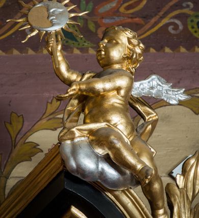 Zdjęcie nr 87: Nastawa architektoniczna, jednoosiowa, jednokondygnacyjna ze zwieńczeniem, ustawiona na dwustrefowym cokole z wyodrębnionymi prostopadłościanami. Ołtarz drewniany, prostopadłościenny z drewnianą mensą. Antepedium wydzielone ramą i wysunięte do przodu, ujęte pilastrami dźwigającymi niepełne belkowanie, w polu wieniec laurowy z rozetą, nad nim kokarda z karbowanej wstęgi flankowana przez dwa podwieszone festony z tkaniny, poniżej wić roślinna. Na ołtarzu ustawione tabernakulum w formie metalowej skrzynki w drewnianej obudowie, ujęte ustawionymi pod kątem spływami wolutowymi. Ścianka frontowa wypukła, z drewnianymi drzwiczkami w kształcie stojącego prostokąta zamkniętego łukiem półkolistym z płaskorzeźbionym kielichem z hostią i kłosami zbóż. Na nim wysoki tron wystawienia z wypukłym frontem z zamontowanym wtórnie nowym tabernakulum (wcześniej obrotowa nisza). Tron ujęty pilastrami ustawionymi pod kątem, o trzonach przechodzących w spływy wolutowe, dekorowane zwisami kwiatowymi; zwieńczony jest trzema rocaille'owymi kabłąkami dekorowanymi zwisami kwiatowymi, podtrzymującymi figurkę pelikana karmiącego młode w gnieździe. Tabernakulum i tron flankowane spływami z podwieszonymi zwisami kwiatowymi zakończonymi cokołami, dźwigającymi przerwany wolutowy przyczółek z figurkami adorujących aniołów; spływy w górnej części zamknięte fragmentami gzymsu z palmetami. 
Nastawa ujęta dwiema parami pilastrów oraz stojącą na ich tle parą kolumn na cokołach dźwigających pełne belkowanie przerwane nad polem środkowym oraz fragmenty przerwanego, wolutowego przyczółka. Przed wewnętrzną parą pilastrów ustawione figury św. Piotra i św. Pawła; na belkowaniu wazony, na przyczółku putta trzymające słońce i księżyc. W polu środkowym podwójna wnęka w formie stojącego prostokąta zamkniętego łukiem odcinkowym nadwieszonym, ujęta profilowaną ramą, ze znacznie mniejszym obrazem Matki Boskiej w kształcie stojącego prostokąta. Nad nią medalion utworzony z wolut i zwisów, zwieńczony koroną otwartą. Zwieńczenie nastawy w formie trapezu ujętego wolutami spływającymi na belkowanie, zamknięte fragmentem falistego gzymsu, dekorowanym medalionem z Okiem Opatrzności w otoku z obłoków w glorii promienistej oraz gałązkami kwiatowymi. W polu obraz św. Katarzyny w formie zbliżonej do zwieńczenia, o ściętych dolnych narożach, w profilowanej ramie, z gałązkami kwiatowymi. 
Nastawa flankowana uszami utworzonymi z rocaille'u, przytwierdzonymi do ściany. Ujęta parą wsporników na trumienki relikwiarzowe oraz parą dużych konsol dekorowanych rocaille'm z figurami św. Mikołaja i św. Stanisława. Struktura polichromowana w kolorze głębokiej czerwieni z czarnymi profilami; kolumny, ornamentyka i profile złocone i srebrzone.