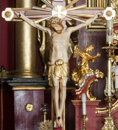 Zdjęcie nr 92: Nastawa architektoniczna, jednoosiowa, jednokondygnacyjna ze zwieńczeniem, ustawiona na dwustrefowym cokole z wyodrębnionymi prostopadłościanami. Ołtarz drewniany, prostopadłościenny z drewnianą mensą. Antepedium wydzielone ramą i wysunięte do przodu, ujęte pilastrami dźwigającymi niepełne belkowanie, w polu wieniec laurowy z rozetą, nad nim kokarda z karbowanej wstęgi flankowana przez dwa podwieszone festony z tkaniny, poniżej wić roślinna. Na ołtarzu ustawione tabernakulum w formie metalowej skrzynki w drewnianej obudowie, ujęte ustawionymi pod kątem spływami wolutowymi. Ścianka frontowa wypukła, z drewnianymi drzwiczkami w kształcie stojącego prostokąta zamkniętego łukiem półkolistym z płaskorzeźbionym kielichem z hostią i kłosami zbóż. Na nim wysoki tron wystawienia z wypukłym frontem z zamontowanym wtórnie nowym tabernakulum (wcześniej obrotowa nisza). Tron ujęty pilastrami ustawionymi pod kątem, o trzonach przechodzących w spływy wolutowe, dekorowane zwisami kwiatowymi; zwieńczony jest trzema rocaille'owymi kabłąkami dekorowanymi zwisami kwiatowymi, podtrzymującymi figurkę pelikana karmiącego młode w gnieździe. Tabernakulum i tron flankowane spływami z podwieszonymi zwisami kwiatowymi zakończonymi cokołami, dźwigającymi przerwany wolutowy przyczółek z figurkami adorujących aniołów; spływy w górnej części zamknięte fragmentami gzymsu z palmetami. 
Nastawa ujęta dwiema parami pilastrów oraz stojącą na ich tle parą kolumn na cokołach dźwigających pełne belkowanie przerwane nad polem środkowym oraz fragmenty przerwanego, wolutowego przyczółka. Przed wewnętrzną parą pilastrów ustawione figury św. Piotra i św. Pawła; na belkowaniu wazony, na przyczółku putta trzymające słońce i księżyc. W polu środkowym podwójna wnęka w formie stojącego prostokąta zamkniętego łukiem odcinkowym nadwieszonym, ujęta profilowaną ramą, ze znacznie mniejszym obrazem Matki Boskiej w kształcie stojącego prostokąta. Nad nią medalion utworzony z wolut i zwisów, zwieńczony koroną otwartą. Zwieńczenie nastawy w formie trapezu ujętego wolutami spływającymi na belkowanie, zamknięte fragmentem falistego gzymsu, dekorowanym medalionem z Okiem Opatrzności w otoku z obłoków w glorii promienistej oraz gałązkami kwiatowymi. W polu obraz św. Katarzyny w formie zbliżonej do zwieńczenia, o ściętych dolnych narożach, w profilowanej ramie, z gałązkami kwiatowymi. 
Nastawa flankowana uszami utworzonymi z rocaille'u, przytwierdzonymi do ściany. Ujęta parą wsporników na trumienki relikwiarzowe oraz parą dużych konsol dekorowanych rocaille'm z figurami św. Mikołaja i św. Stanisława. Struktura polichromowana w kolorze głębokiej czerwieni z czarnymi profilami; kolumny, ornamentyka i profile złocone i srebrzone.