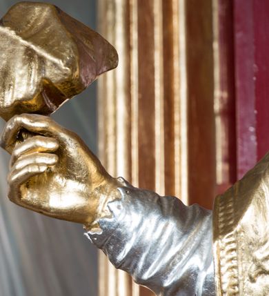 Zdjęcie nr 12: Rzeźba ścięta z tyłu i drążona, ustawiona na niskiej podstawie. Święty ukazany frontalnie, z głową skierowaną w prawo, w kontrapoście, o sylwetce lekko przechylonej w tył. W prawej, uniesionej ręce trzyma kamień, w lewej wysuniętej w bok liść palmy. Twarz ma szczupłą, kwadratową, o wyraźnie zarysowanej żuchwie, niewielkich, migdałowatych oczach, osadzonych blisko siebie, małym nosie i wąskich ustach. Włosy krótkie, silnie kręcone. Święty ubrany jest w albę, stułę skrzyżowaną na prawym boku, humerał, dalmatykę z płaskorzeźbionym wzorem kwiatowym i rocaille&#039;em, na lewym przedramieniu ma manipularz. Figura niemal w całości złocona, alba i humerał srebrzone.