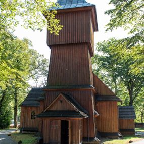 Zdjęcie nr 1: Kościół parafialny w Gruszowie znajduje się na niewielkim wzniesieniu w centrum miejscowości. Budowla jest orientowana, jednonawowa, z szerokim zamkniętym trójbocznie prezbiterium oraz czworoboczną wieżą od zachodu. Korpusu nawowy i prezbiterium charakteryzuje konstrukcja zrębowa, natomiast wieżę słupowa. Od północy do prezbiterium przylega zakrystia na rzucie prostokąta, natomiast do nawy zamknięta trójbocznie kaplica boczna. Do wnętrza kościoła prowadzą dwie kruchty, jedna od strony południowej, druga przez wieżę od zachodniej. Nad korpusem nawowym i prezbiterium znajduje się jednokalenicowy dach kryty gontem, a na styku nawy i prezbiterium usytuowana jest drewniana wieżyczka na sygnaturkę nakryta baniastym hełmem z latarnią. Zakrystia przekryta jest dachem pulpitowym, natomiast kaplica boczna oraz kruchty dachami dwuspadowymi krytymi gontem. Izbicową, o pochyłych ścianach wieżę wieńczy okuty blachą dach namiotowy. Elewacje osłania szalunek z pionowych desek z tzw. listwowaniem oraz pseudopilastry, dodatkowo wieżę w jednej trzeciej wysokości obiega niewielki parapet kryty gontem. W strukturze korpusu nawowego otwory okienne znajdują się po stronie południowej i mają kształt stojących prostokątów. W prezbiterium znajduje się po jednym oknie od południa i od wschodu, ich prostokątna forma jest zamknięta łukiem w ośli grzbiet. W kaplicy bocznej jest jedno okno od strony zachodniej. Ściana wschodnia zakrystii przepruta jest dwoma niewielkimi oknami, natomiast kruchty południowej jednym. W kruchcie zachodniej od południa jest jedno okno, natomiast w dolnej partii wieży znajdują się trzy, z czego dwa dolne oddziela od górnego niewielki daszek pulpitowy. Wnętrze korpusu nawowego i prezbiterium kościoła nakryte jest drewnianym stropem. Do kaplicy bocznej prowadzi szerokie przejście o ostrołukowym wykroju. Południowy portal w korpusie nawowym wieńczy wykrój w formie łuku w ośli grzbiet. Ściany i stropy wnętrza kościoła pokrywa secesyjna polichromia. 
Plac przykościelny otoczony jest drewnianym ogrodzeniem oraz starodrzewem.
